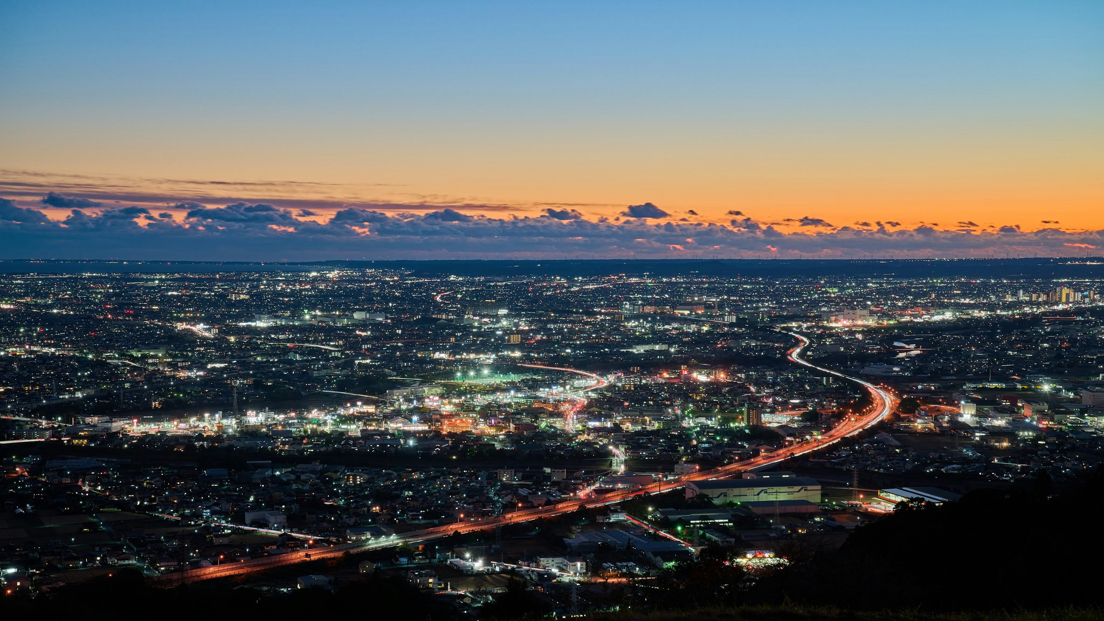 Vista panorámica de un paisaje urbano al atardecer con un río sinuoso