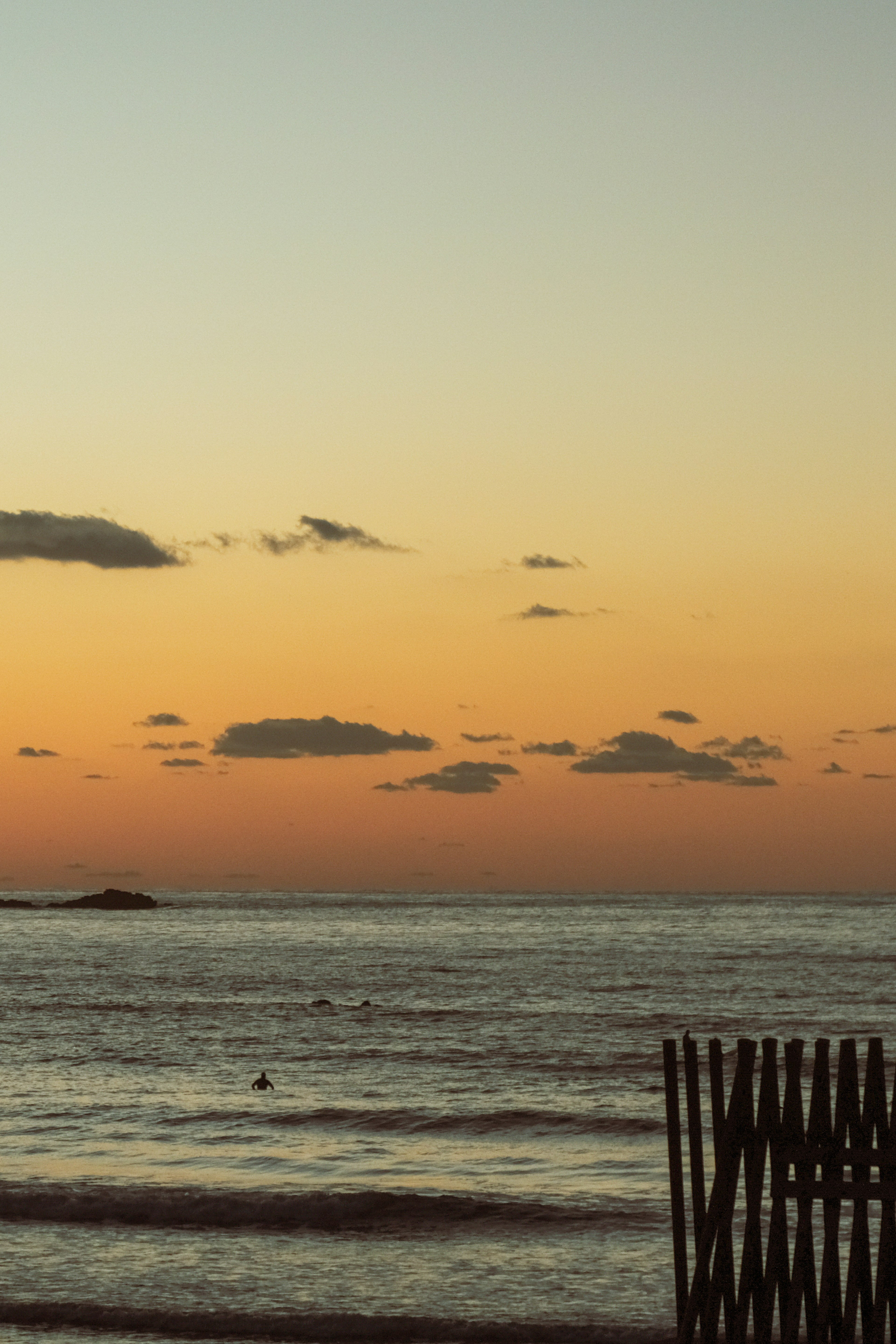 海と夕焼けの風景、穏やかな波とオレンジ色の空