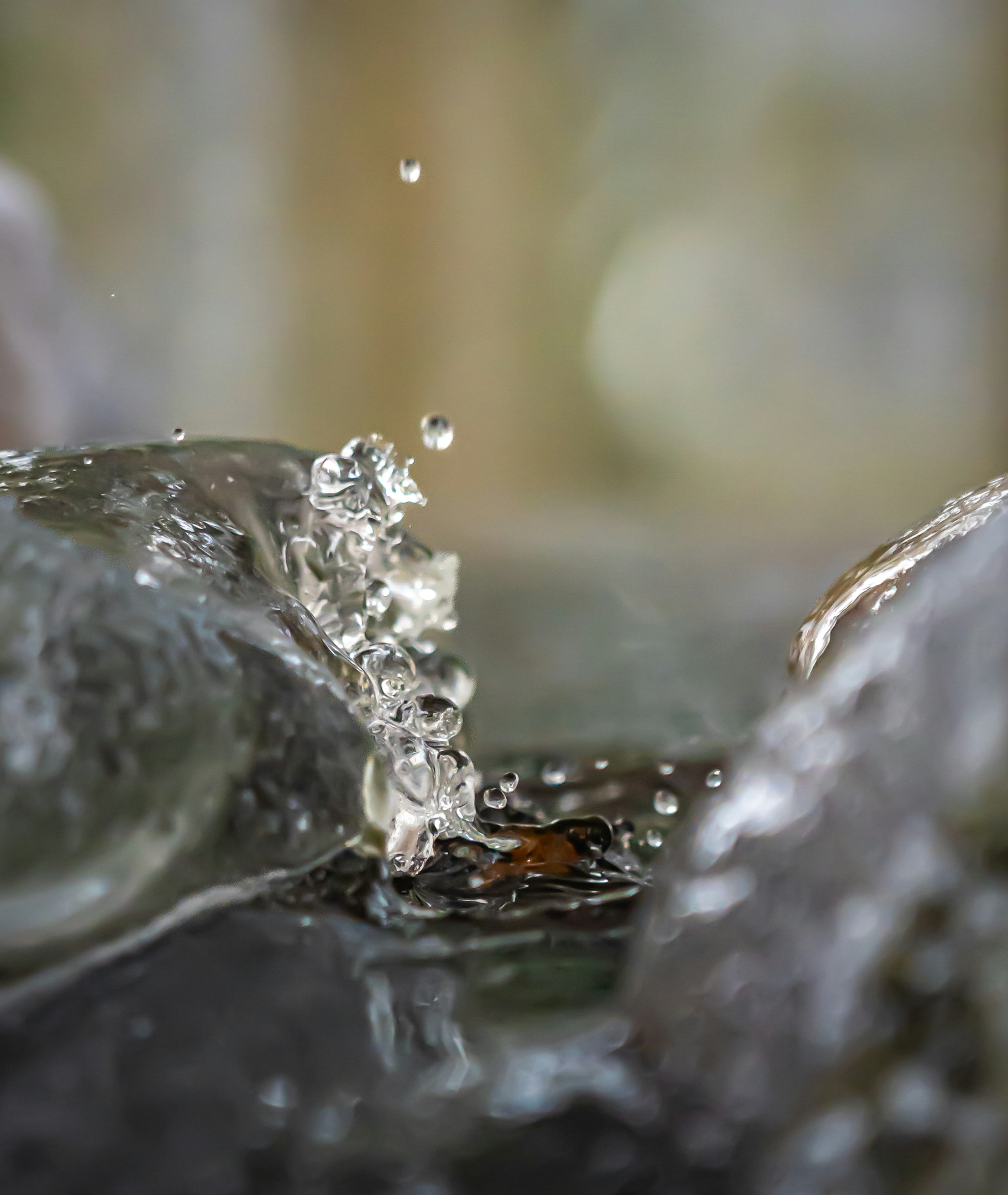 水のしずくが石の間に落ちる様子を捉えた美しい写真