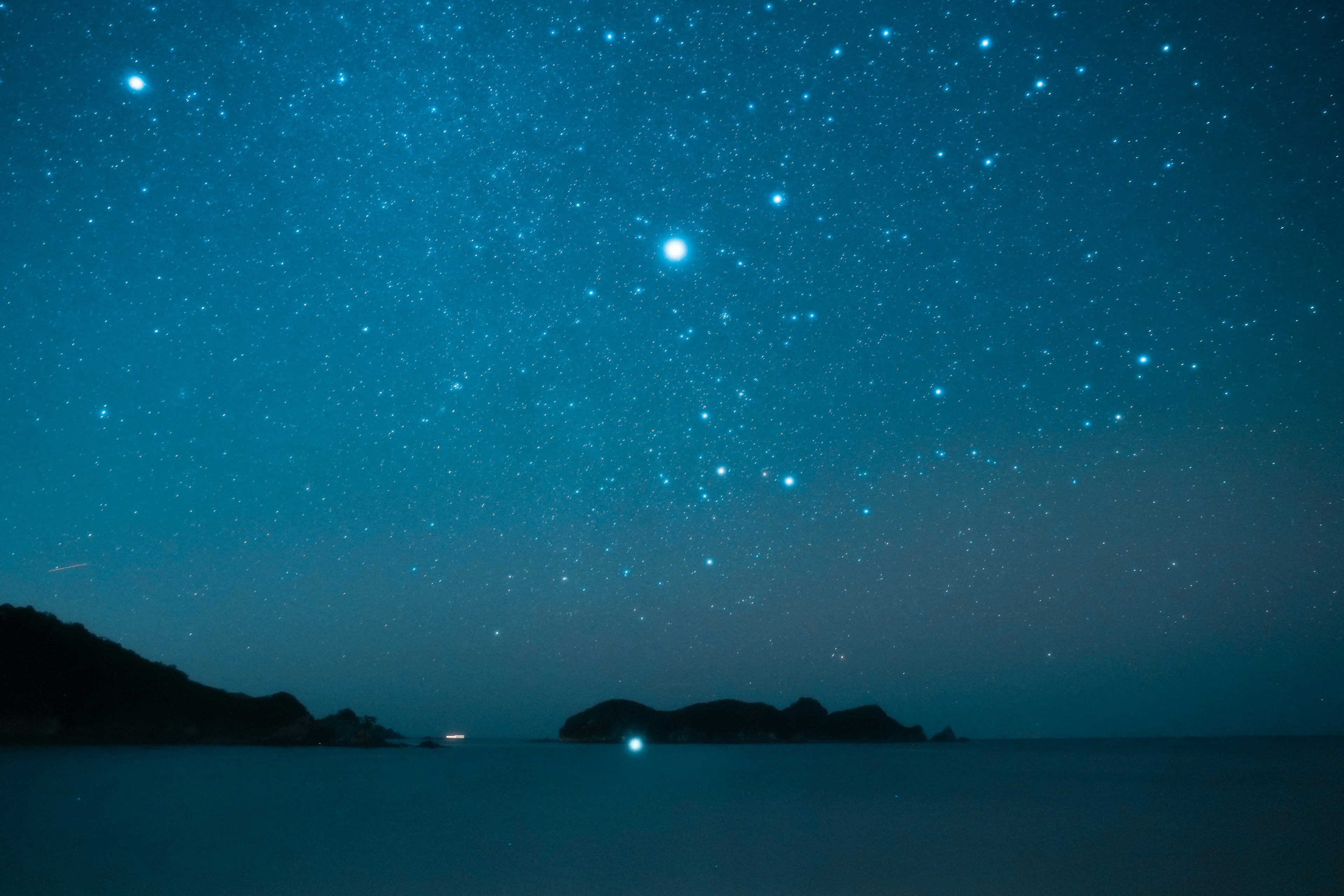 Langit berbintang di atas lautan tenang dengan bintang yang terlihat