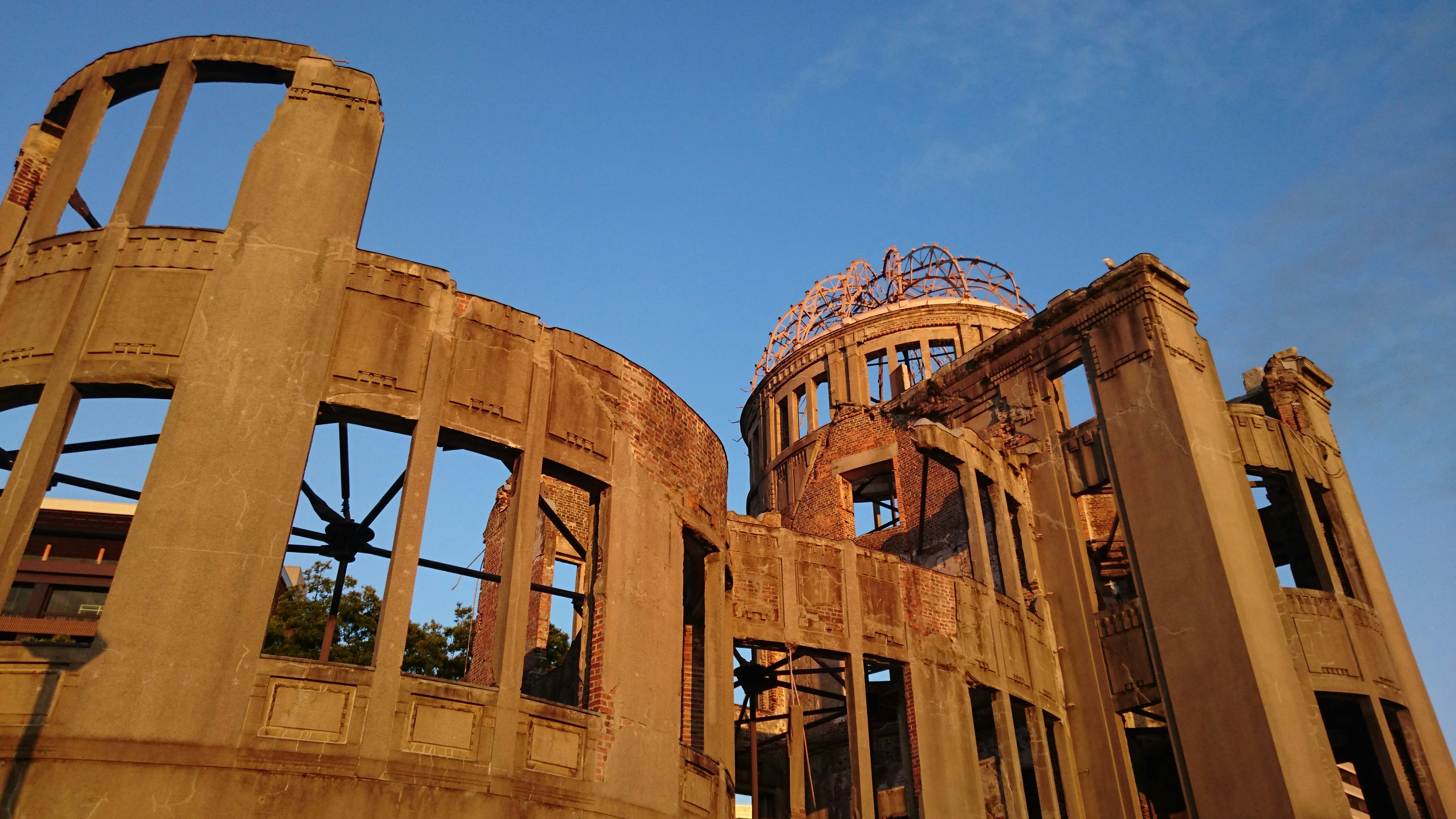 Tampilan luar Monumen Perdamaian Hiroshima dengan latar belakang langit biru