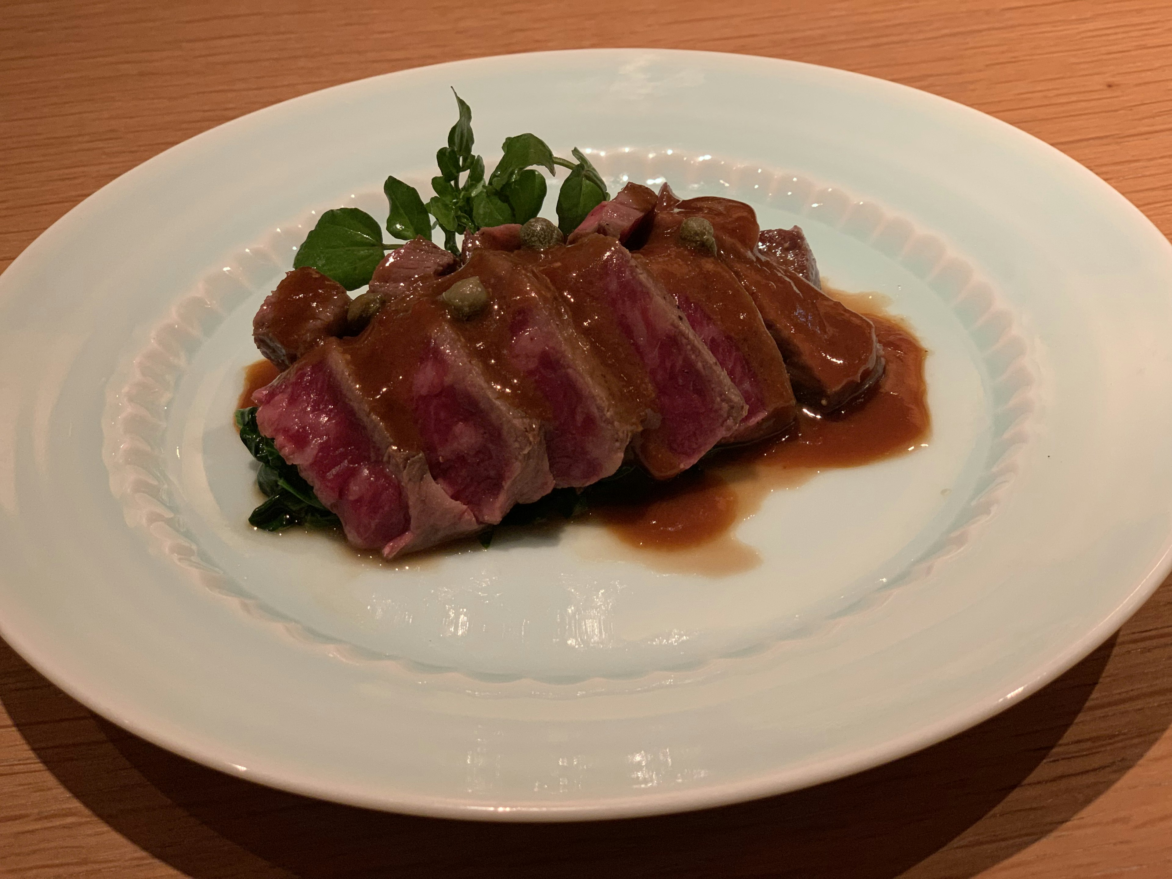 薄切りの肉にソースをかけた美しいプレート