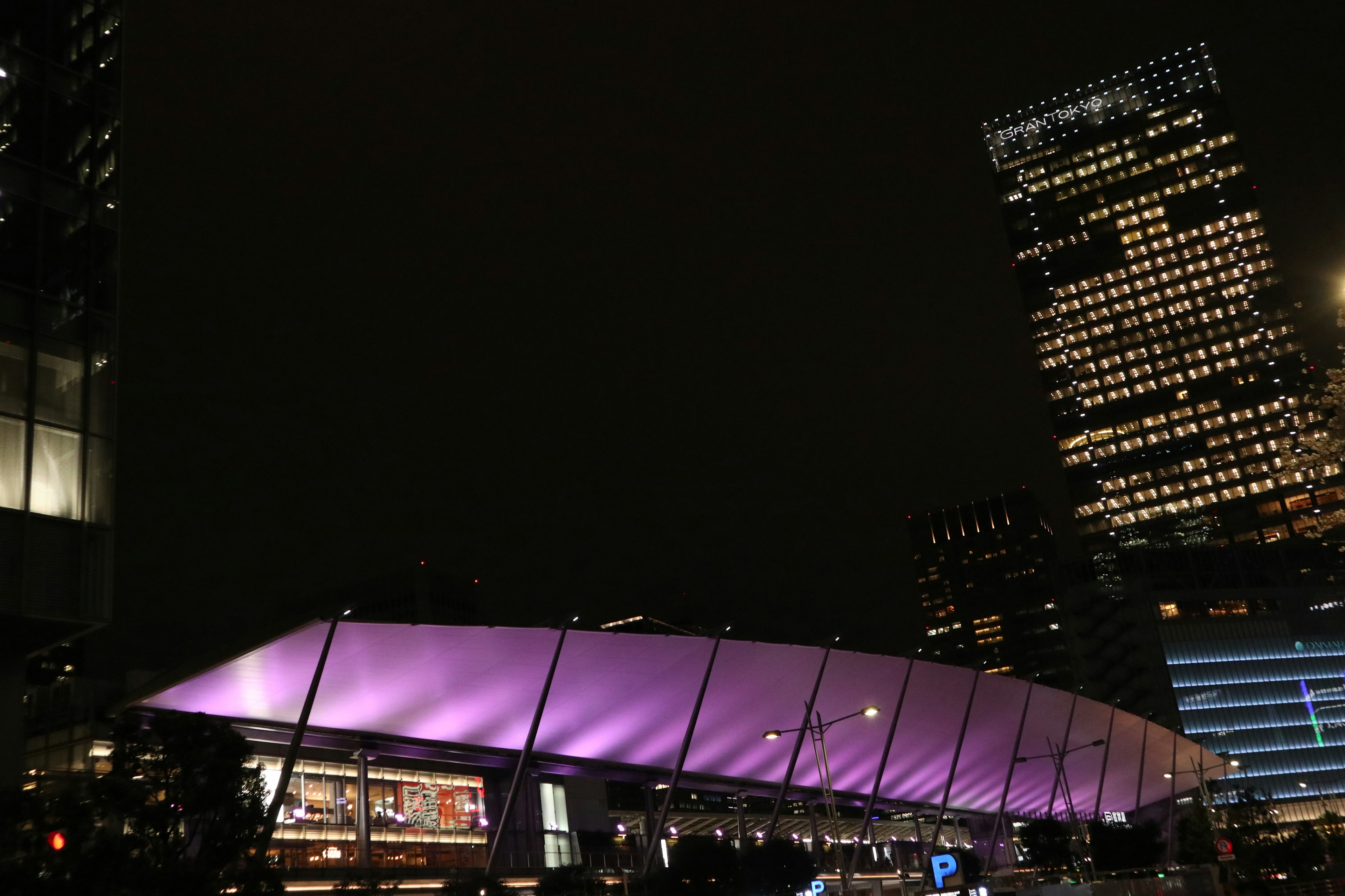 Edificio moderno con un tetto viola in un paesaggio urbano notturno