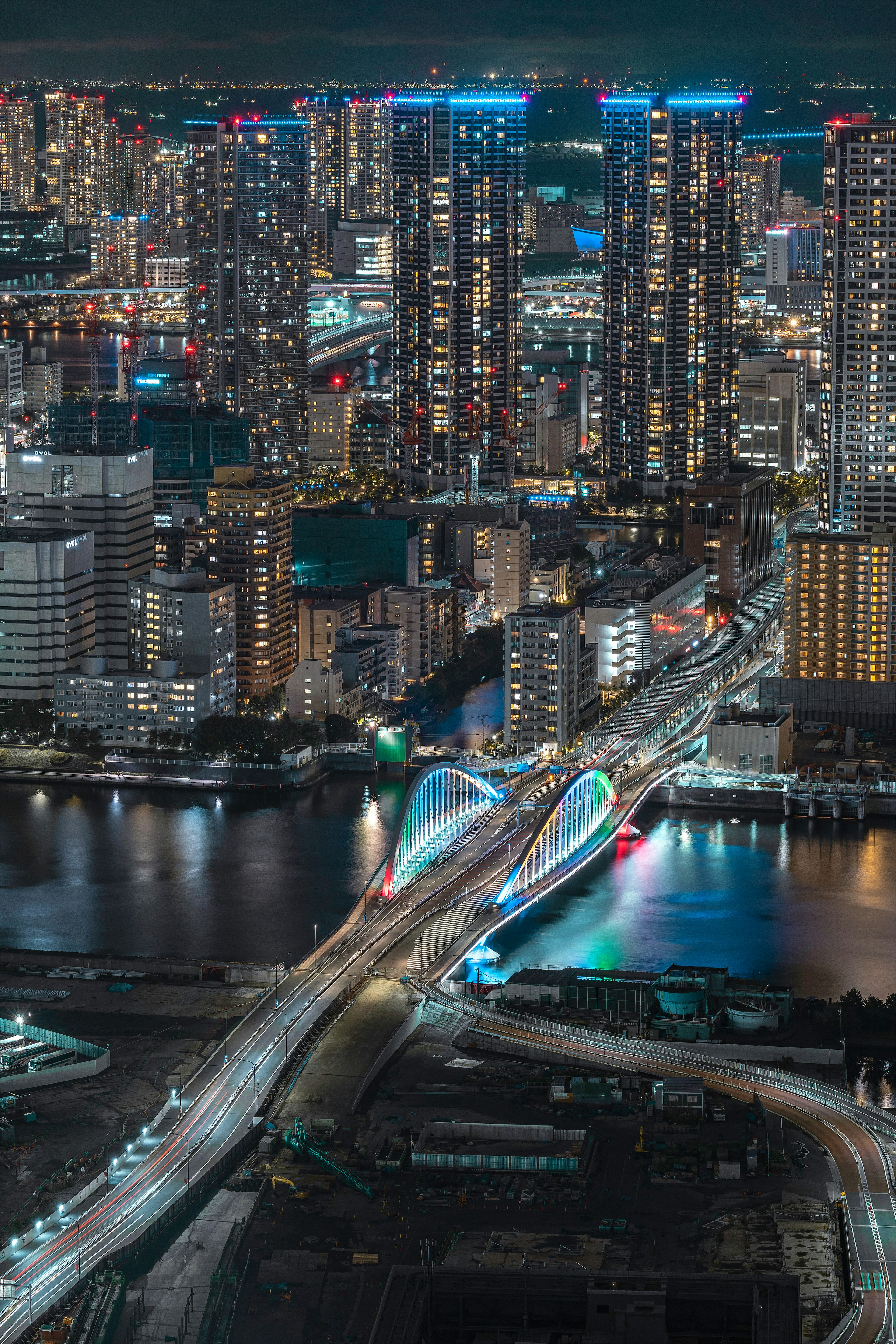 Stunning night cityscape featuring illuminated buildings and a unique bridge