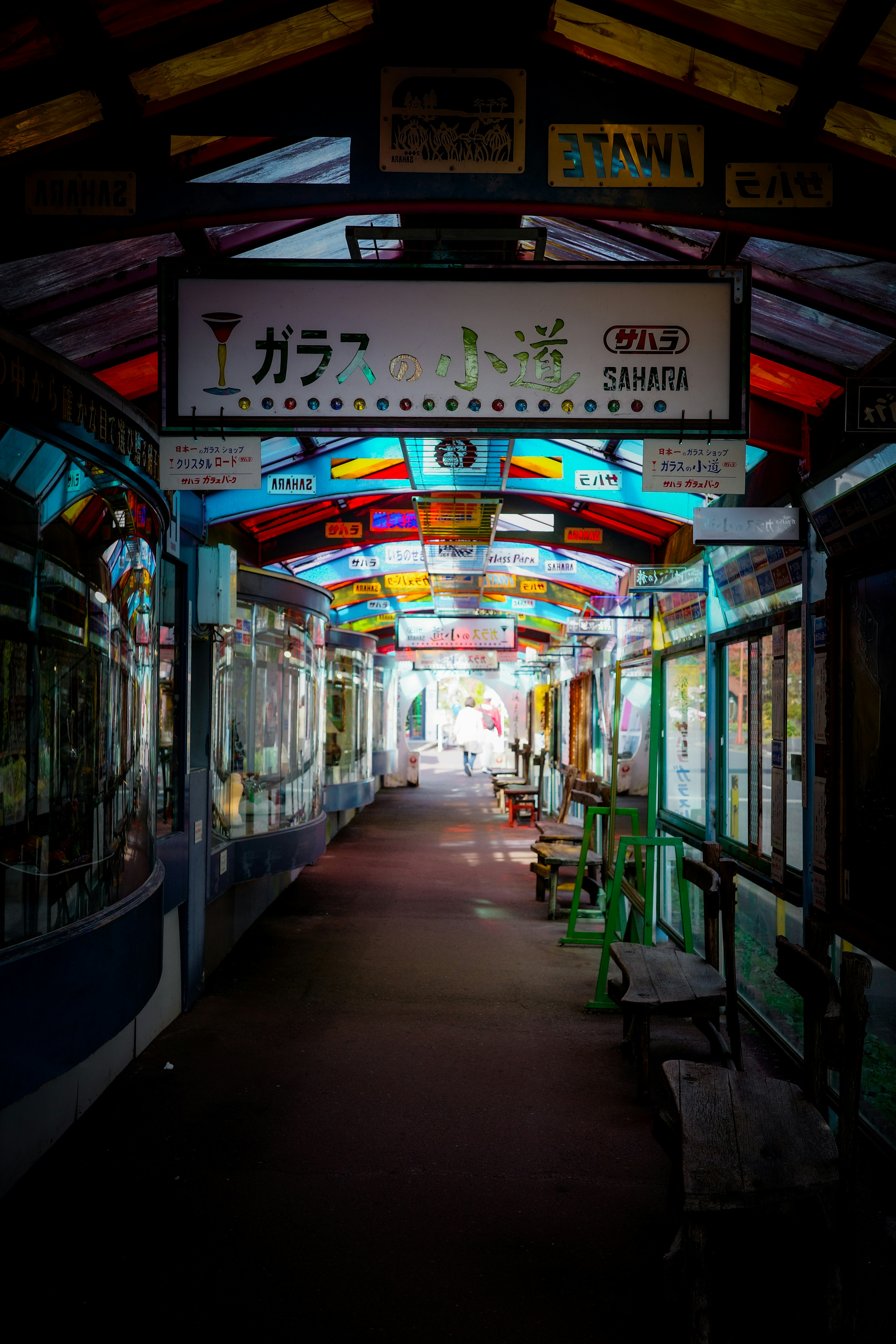 Lorong tertutup berwarna-warni dengan langit-langit cerah dan bangku