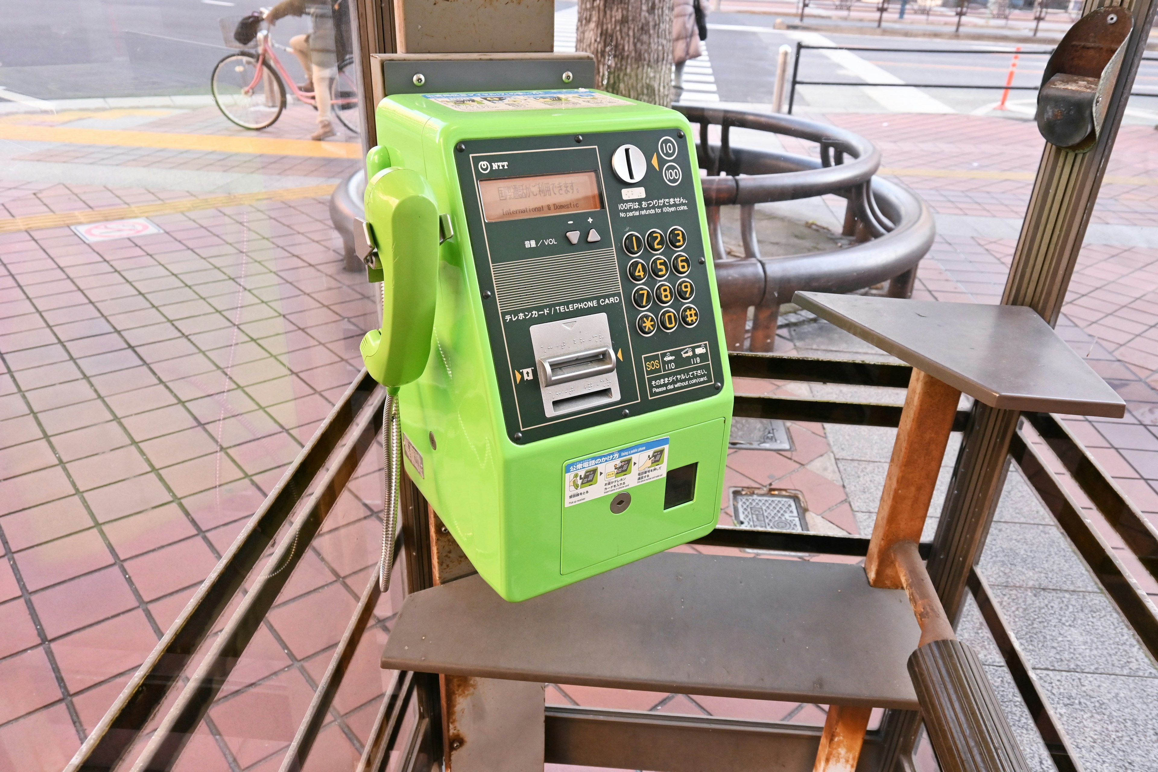 Téléphone public vert installé à un arrêt de bus