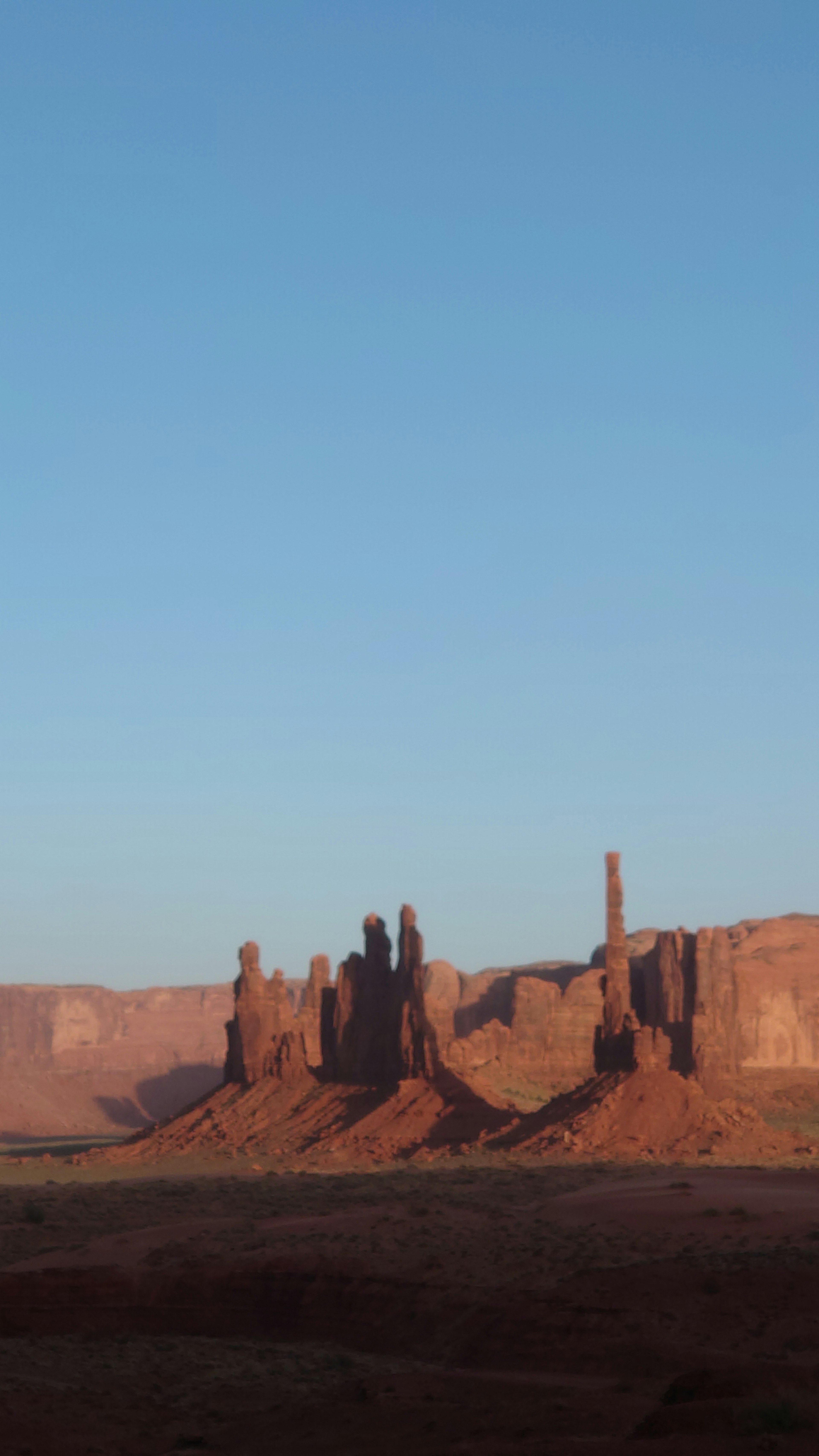 รูปแบบหินสีแดงของ Monument Valley ใต้ท้องฟ้าสีฟ้าสดใส