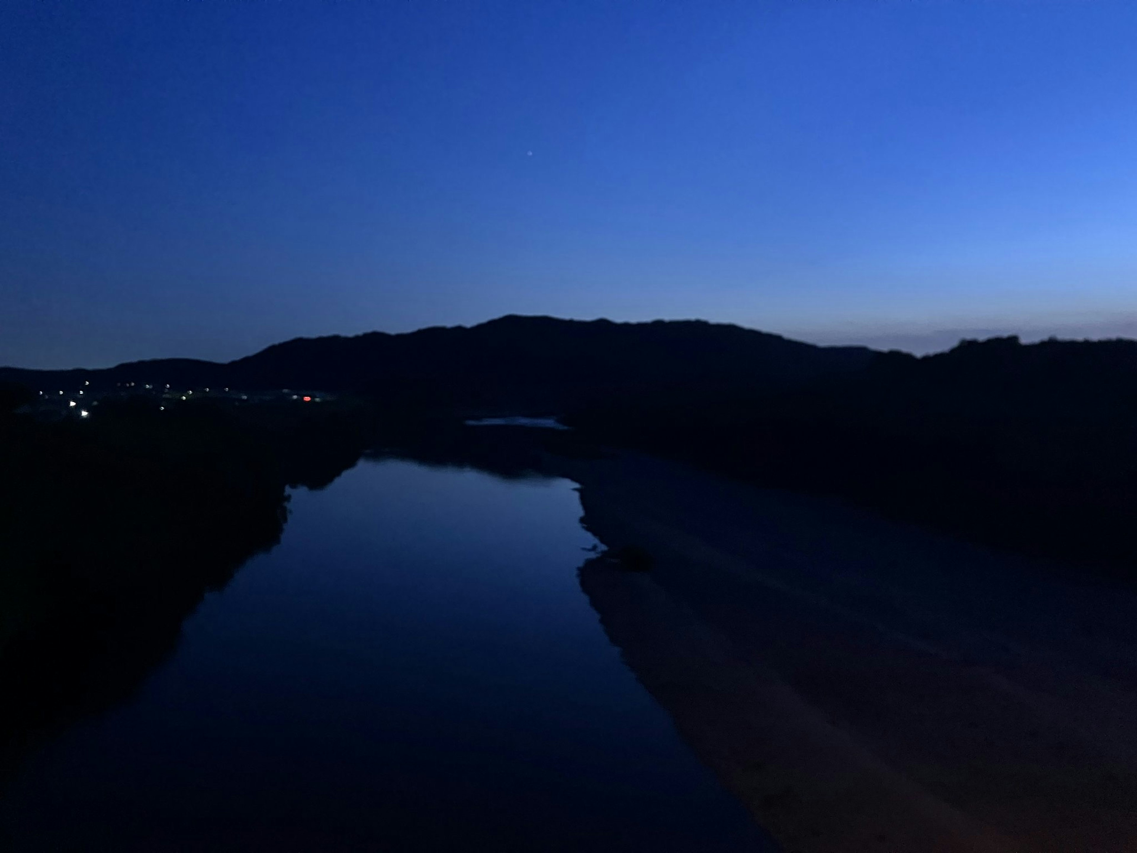 暗い川と山々が見える夜の風景