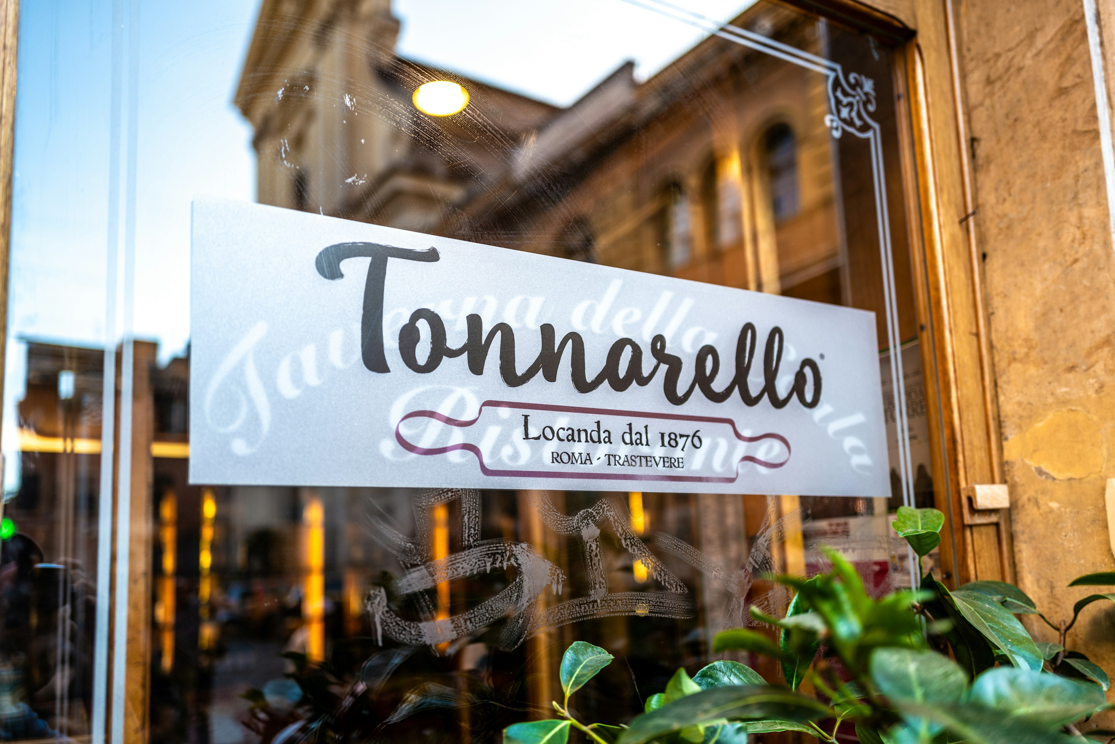 Panneau du restaurant Tonnarello visible sur une fenêtre de café