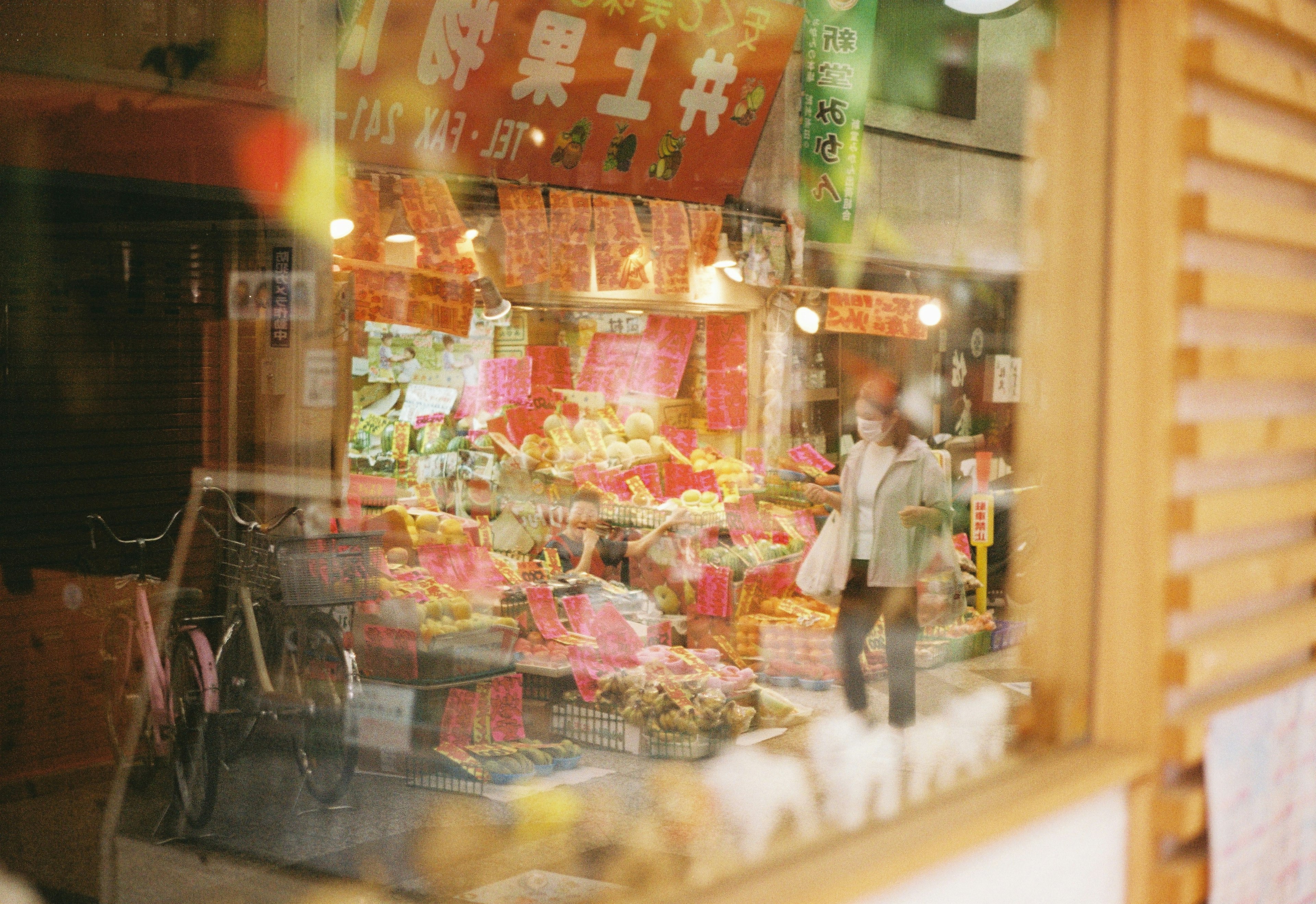 Vibrant market scene with colorful fruits and a passerby