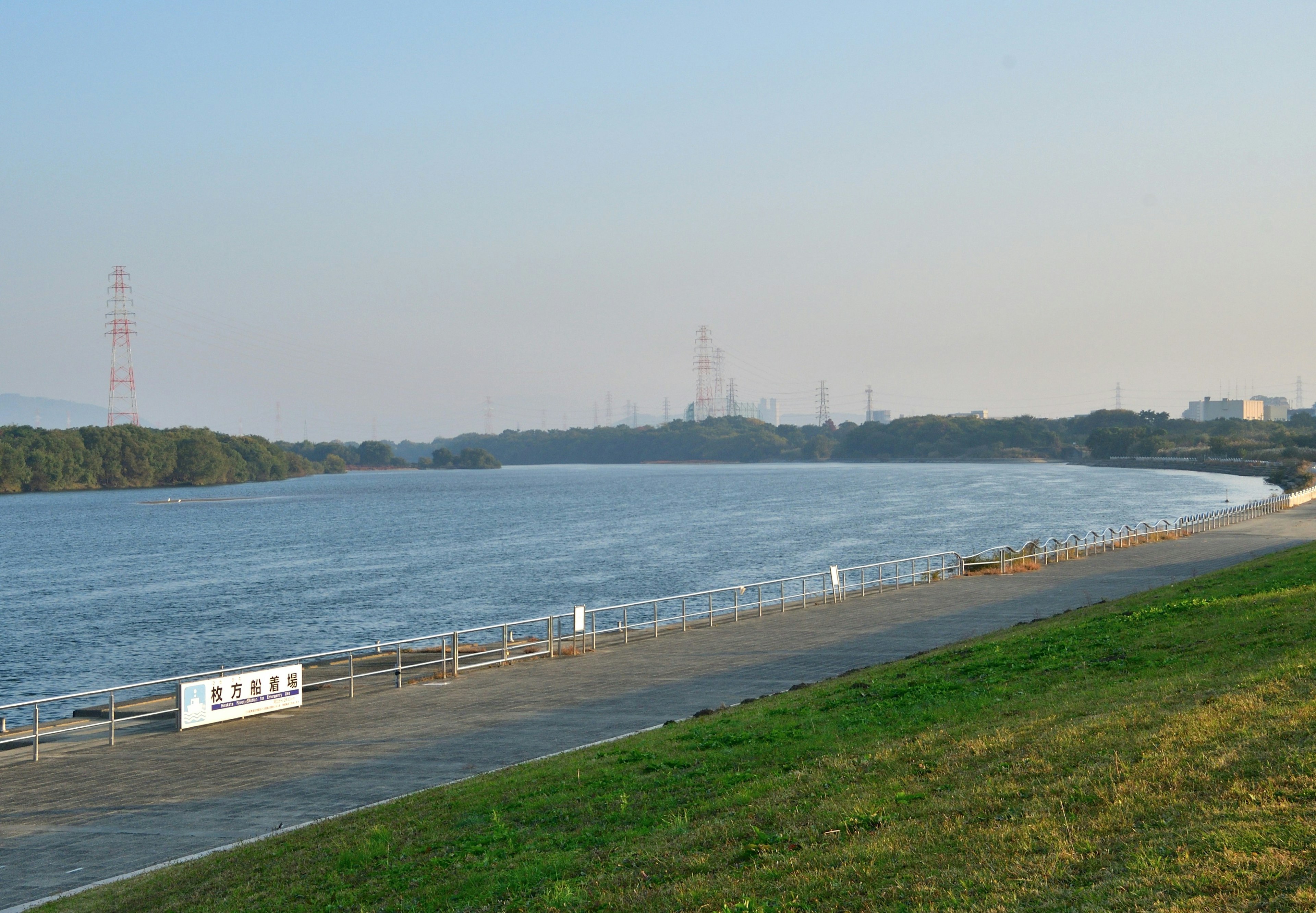 Scenic river view with green grass under gentle sunlight