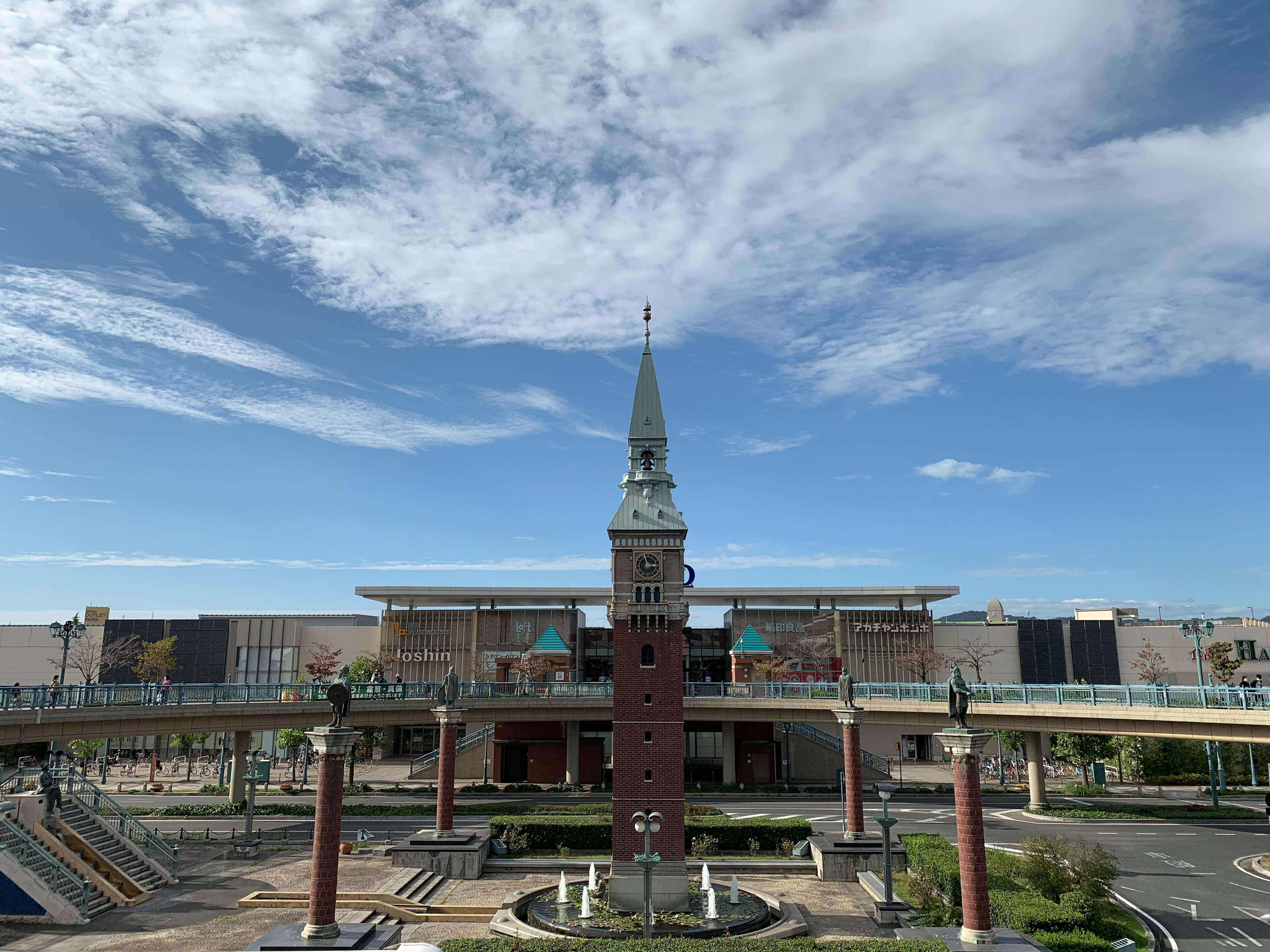 View of a square with a tall clock tower and modern architecture