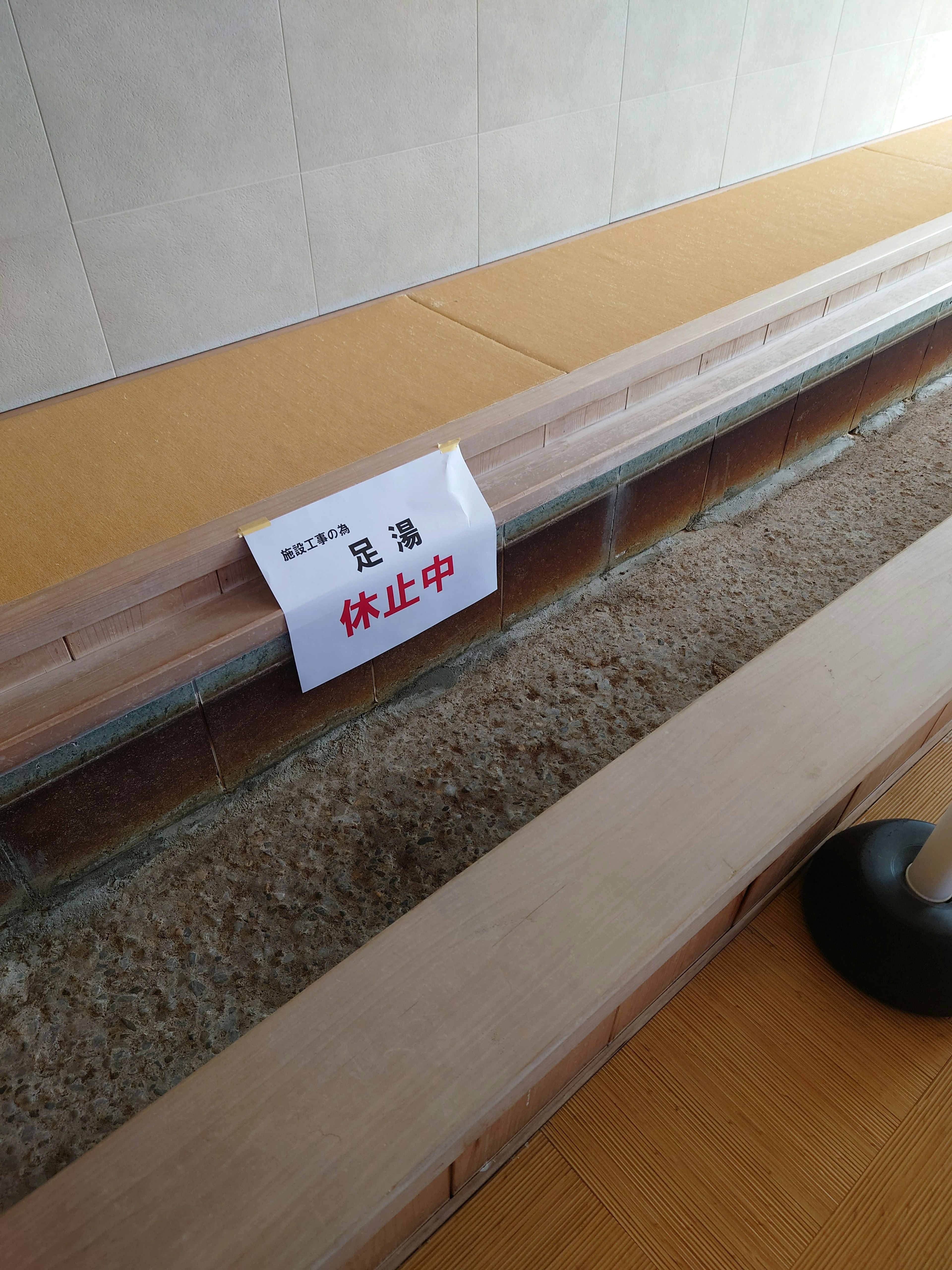 Indoor scene with wooden railing and a notice sign