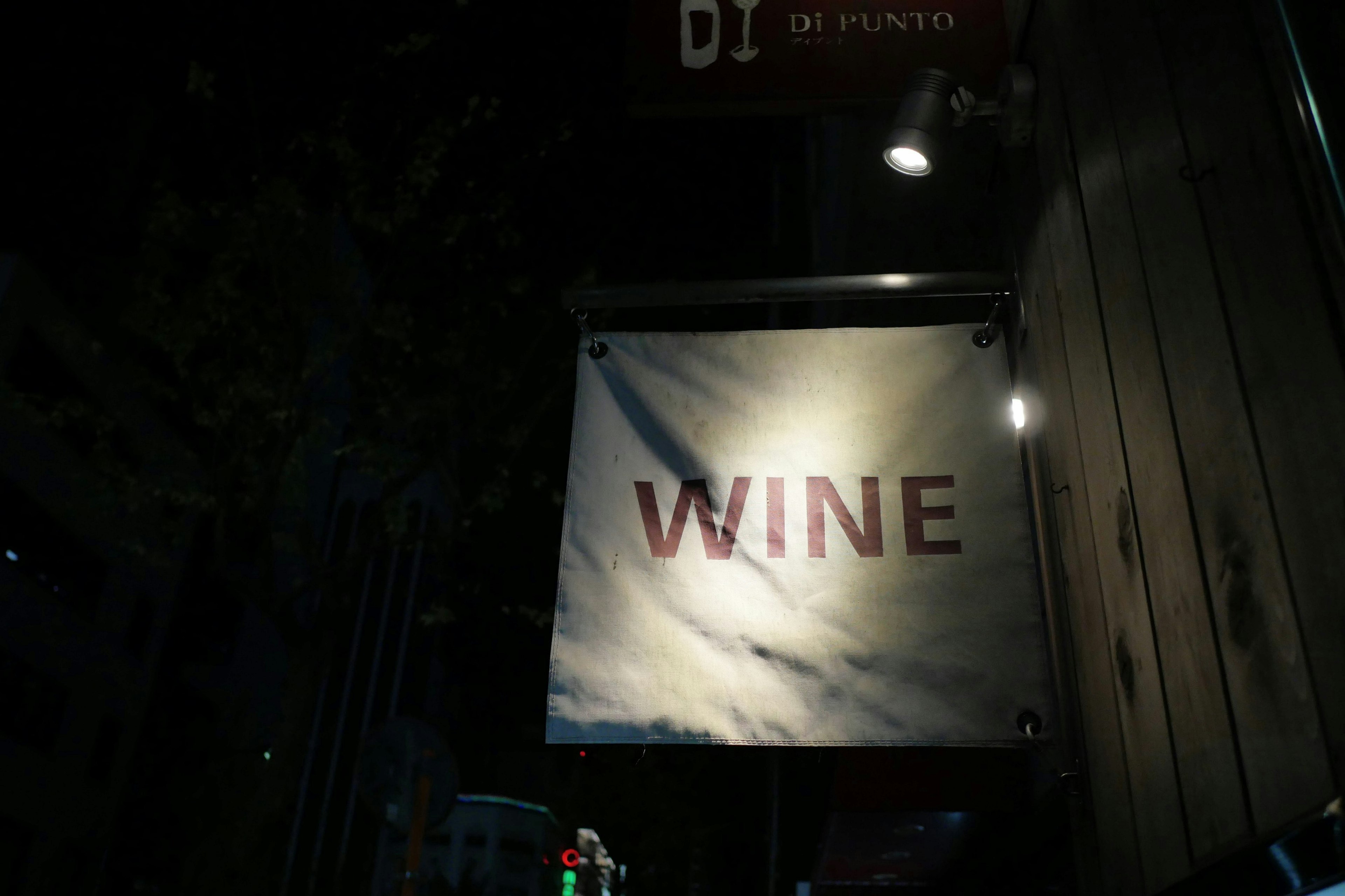 Nighttime sign featuring the word 'WINE' in bold red letters