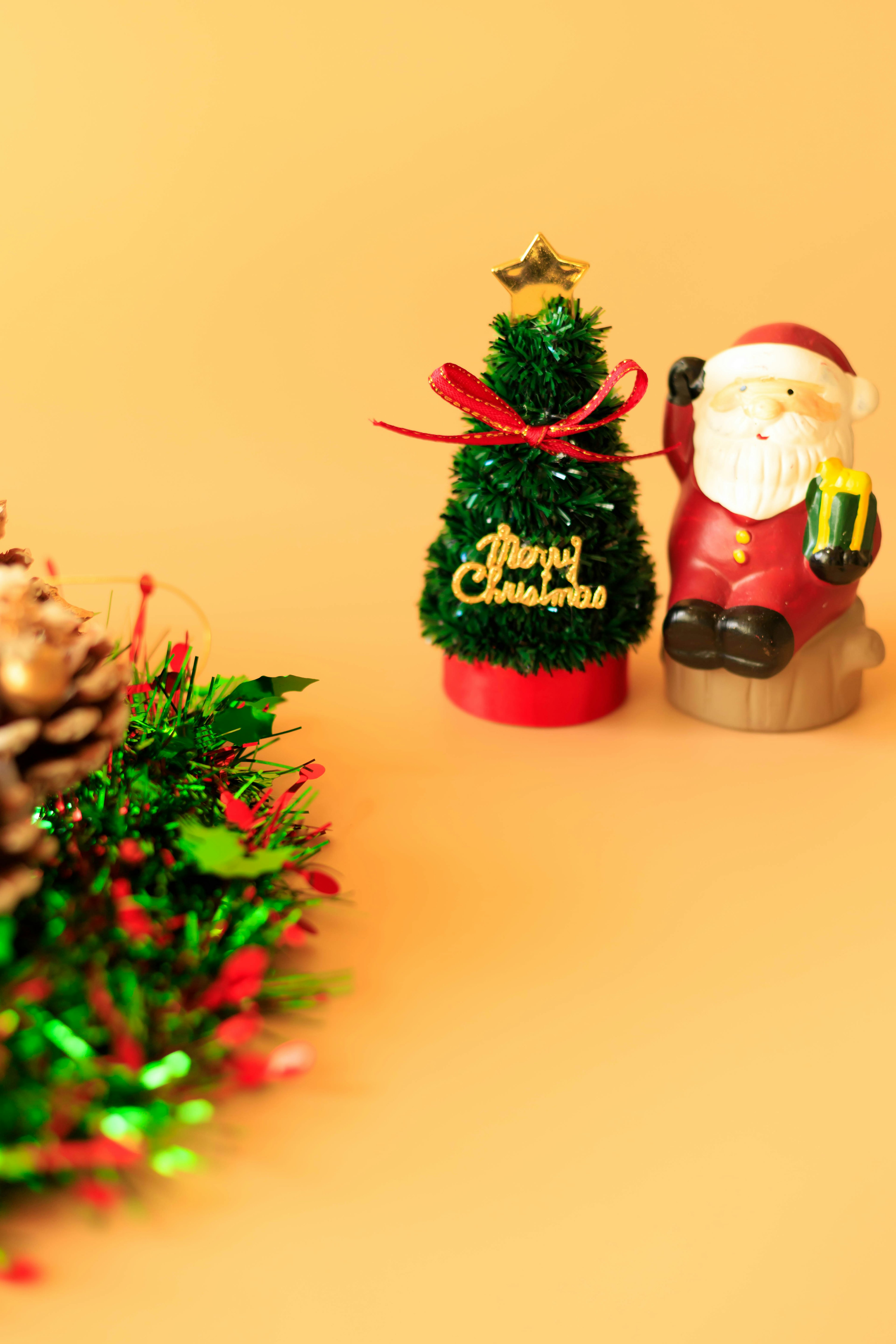 Miniature Christmas tree and Santa figurine against a warm background