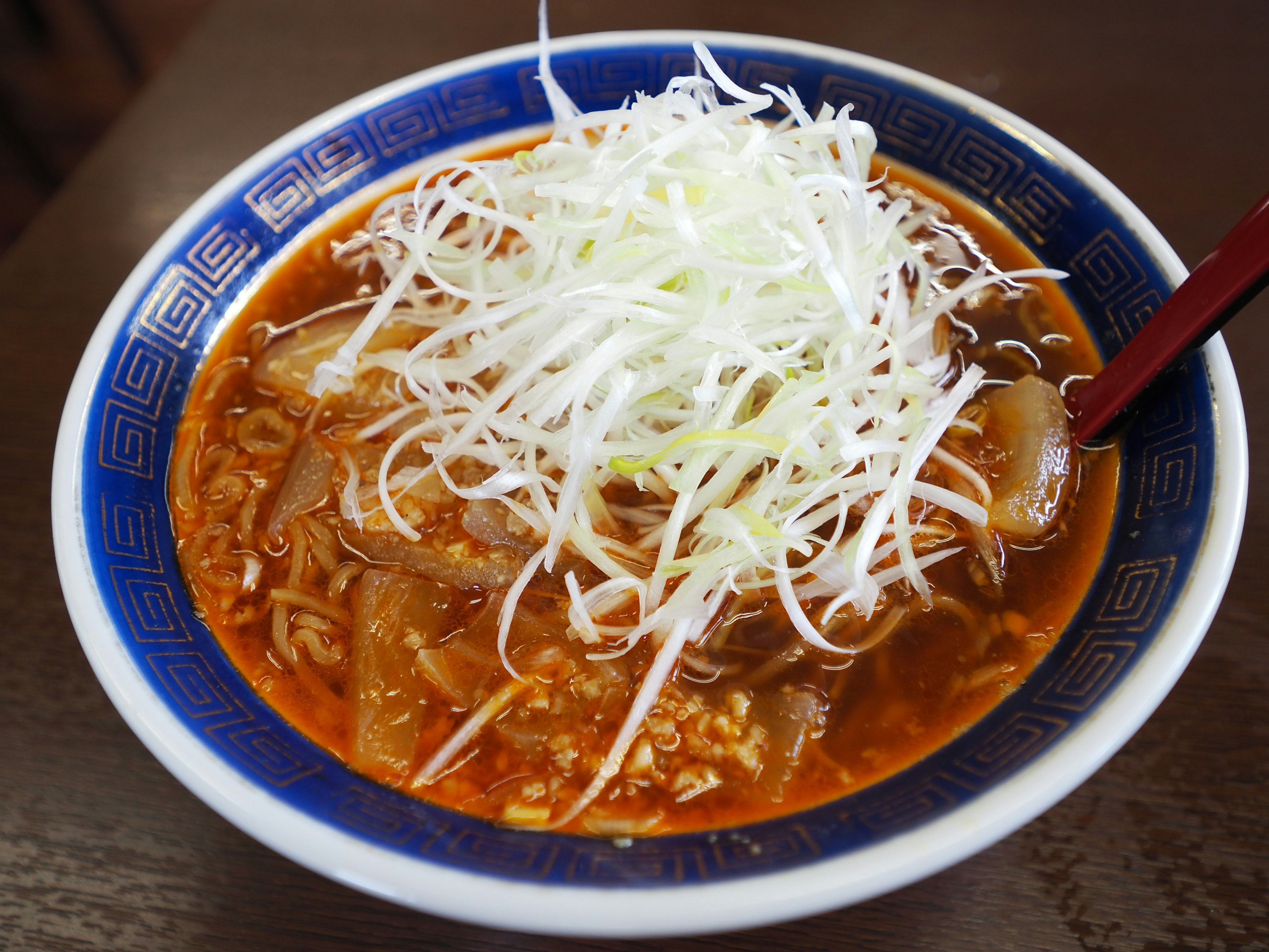 Schüssel mit scharfem Ramen, garniert mit gehackten weißen Frühlingszwiebeln