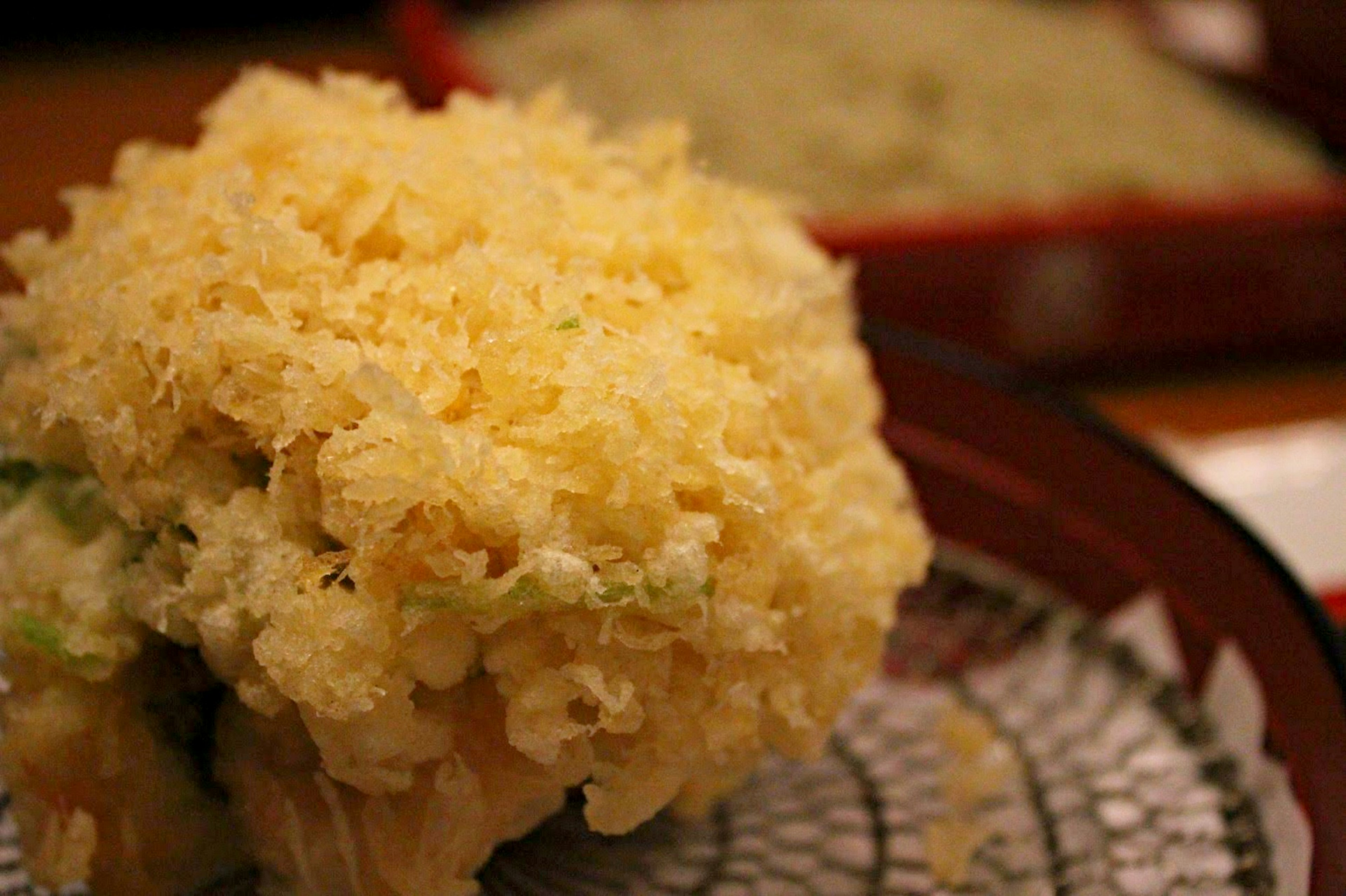 Tempura crujiente servido en un plato con diseño de malla