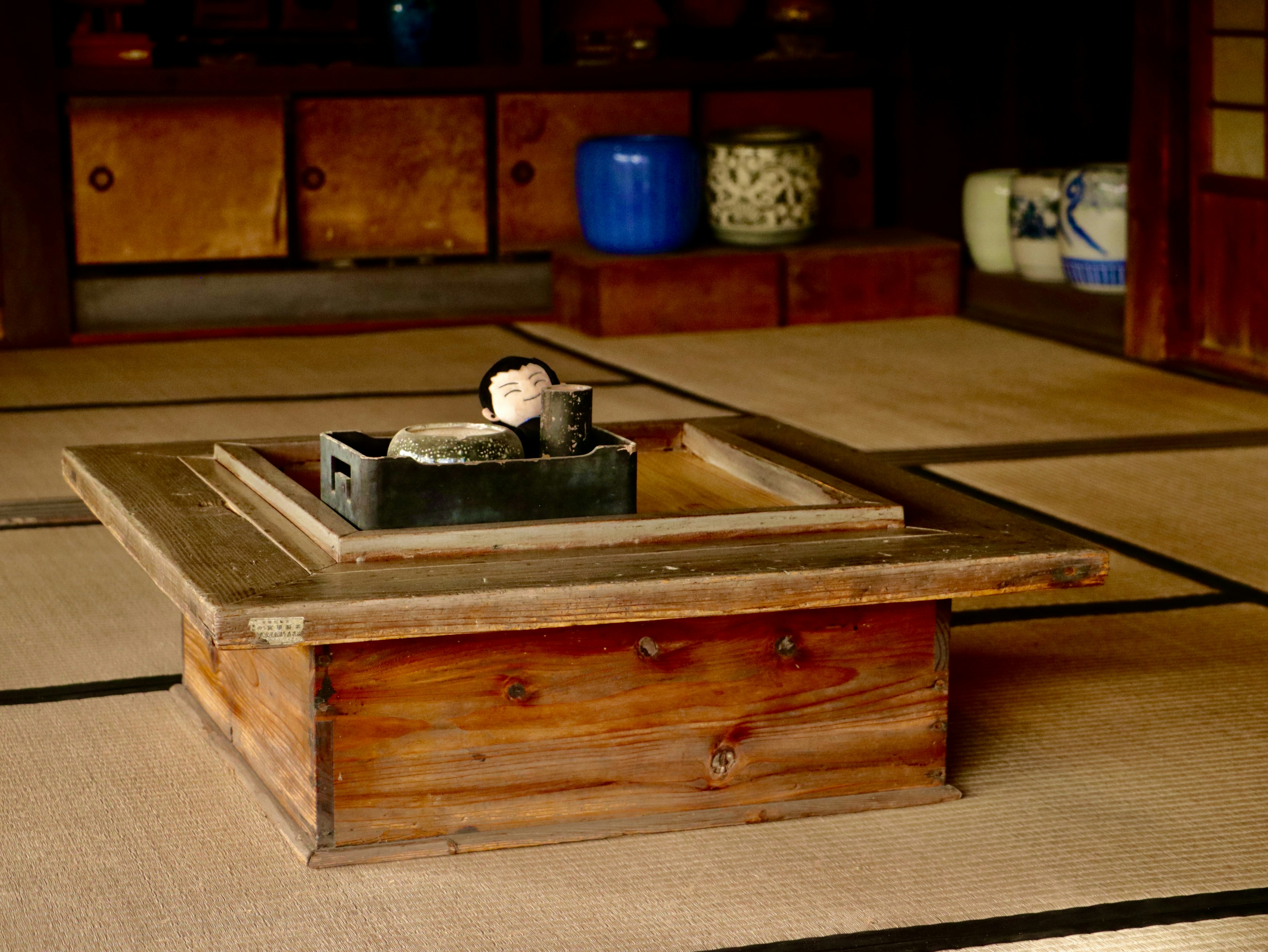 Habitación japonesa tradicional con un irori de madera y suelo de tatami