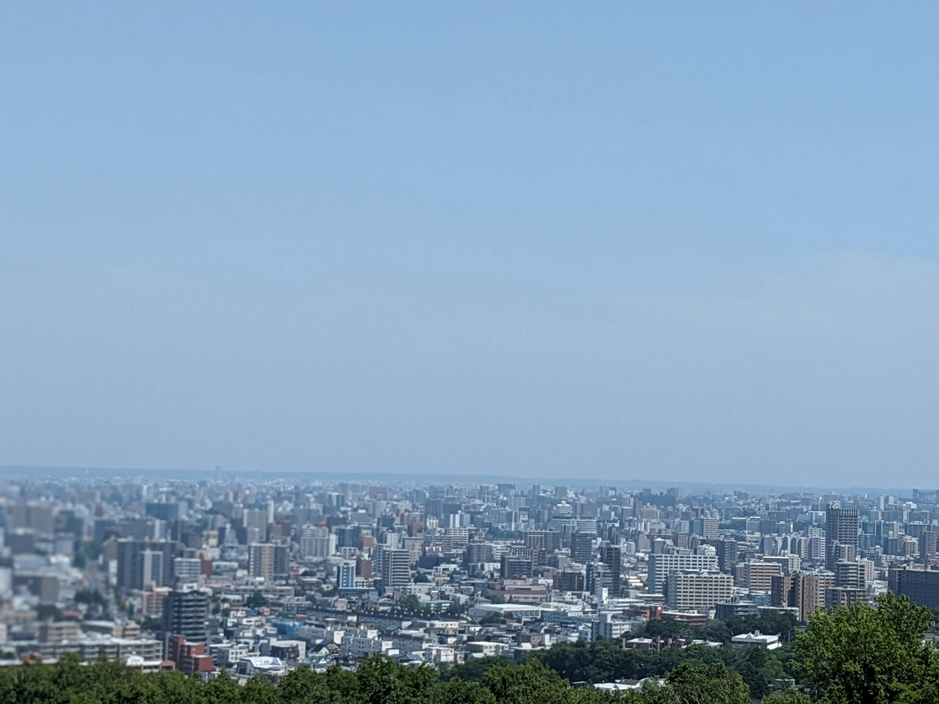 Vista panorámica de una ciudad bajo un cielo azul con rascacielos y edificios residenciales