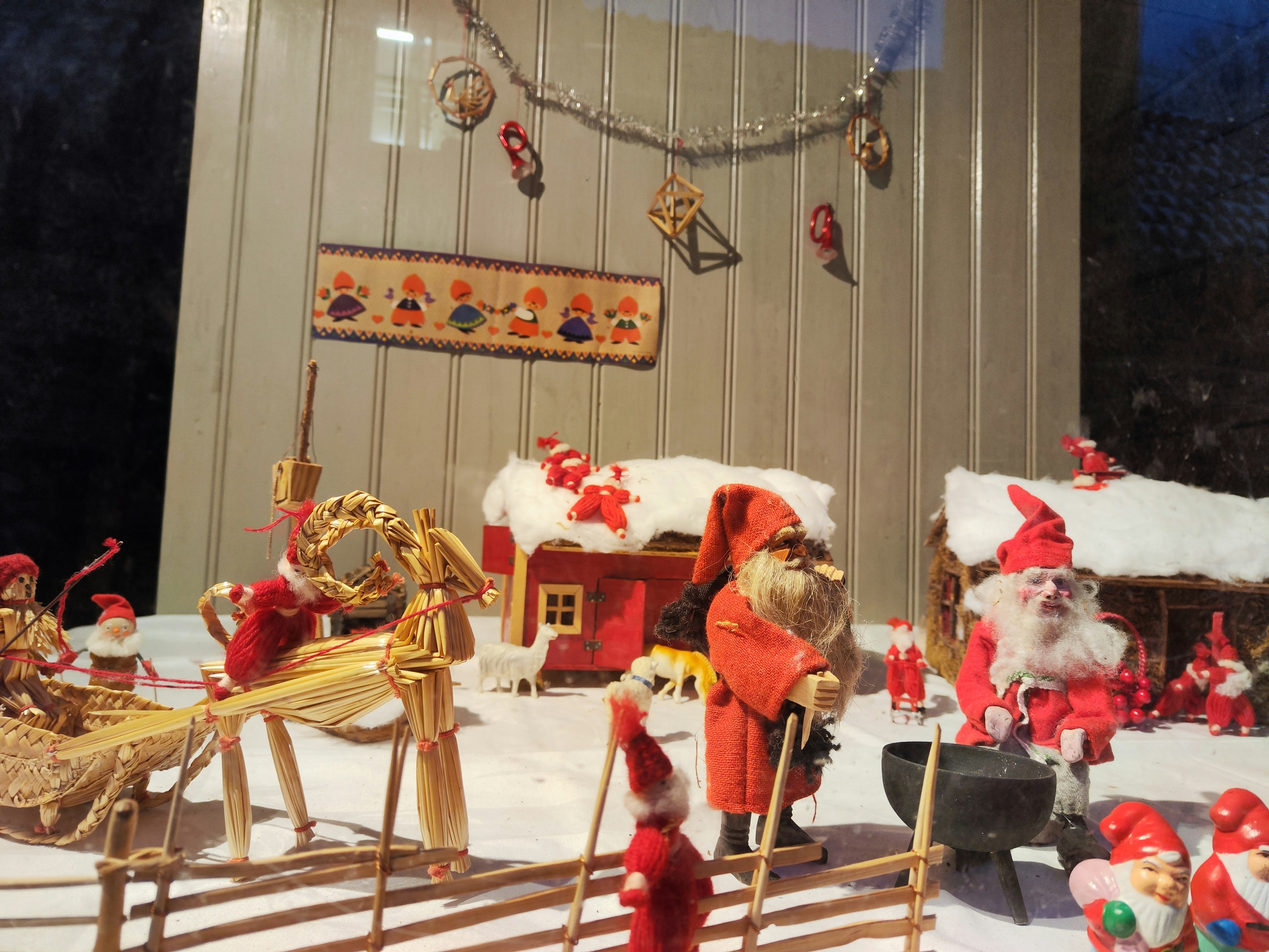 Una pequeña exhibición de un pueblo navideño con Santa Claus y casas en la nieve