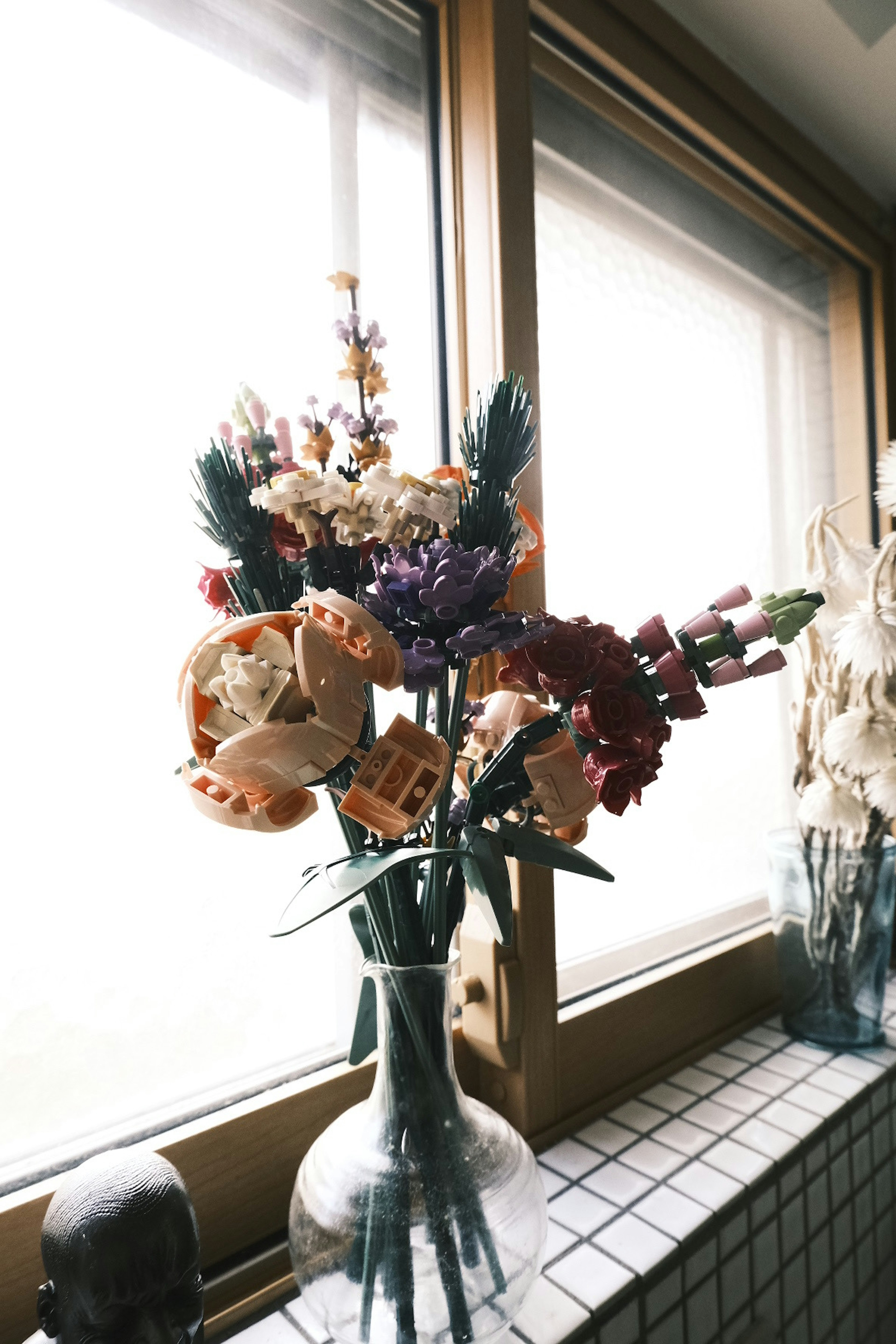 Colorful bouquet in a glass vase by a window