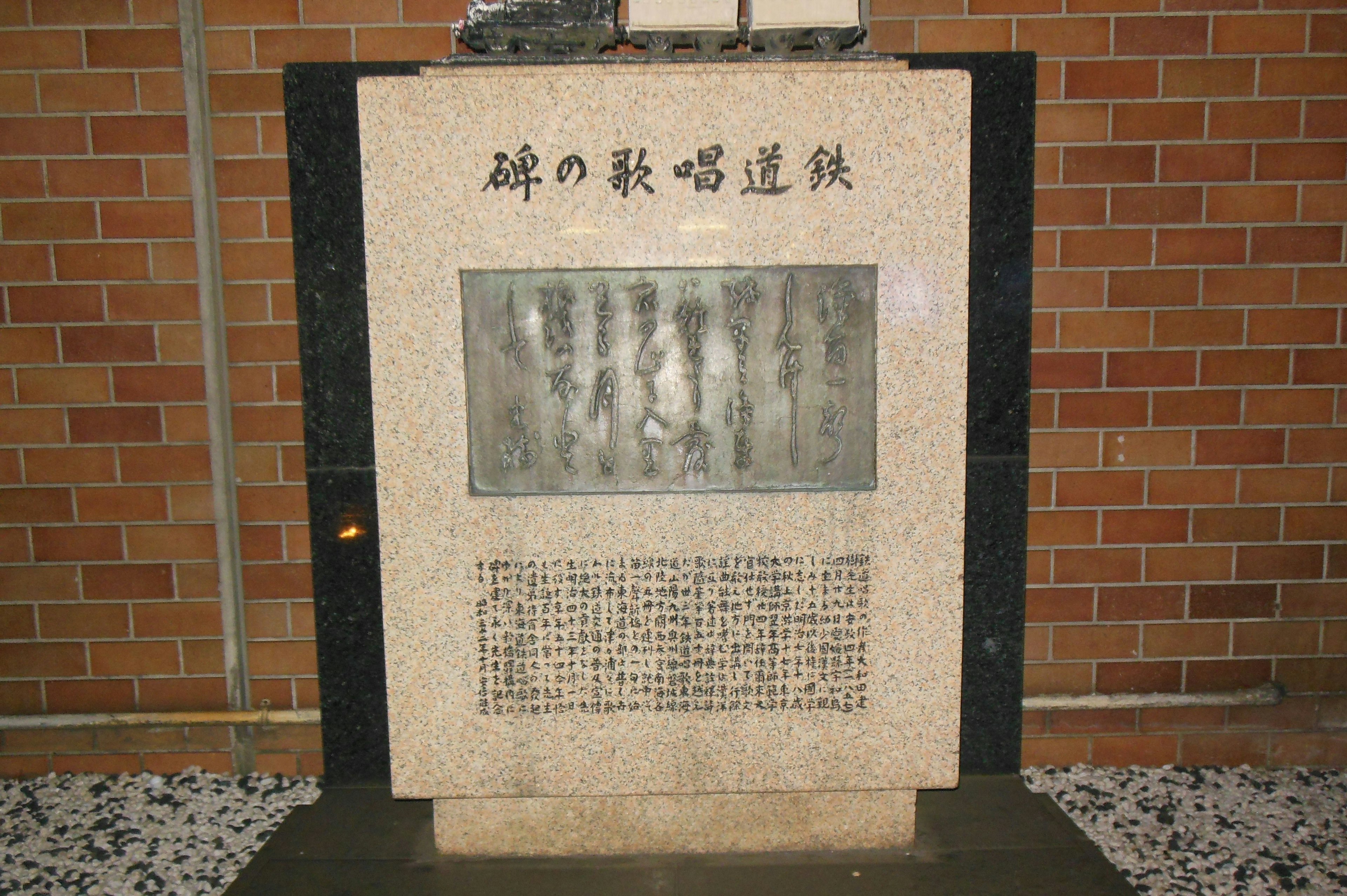 Monumento in pietra con un pannello scolpito e testo inciso sotto