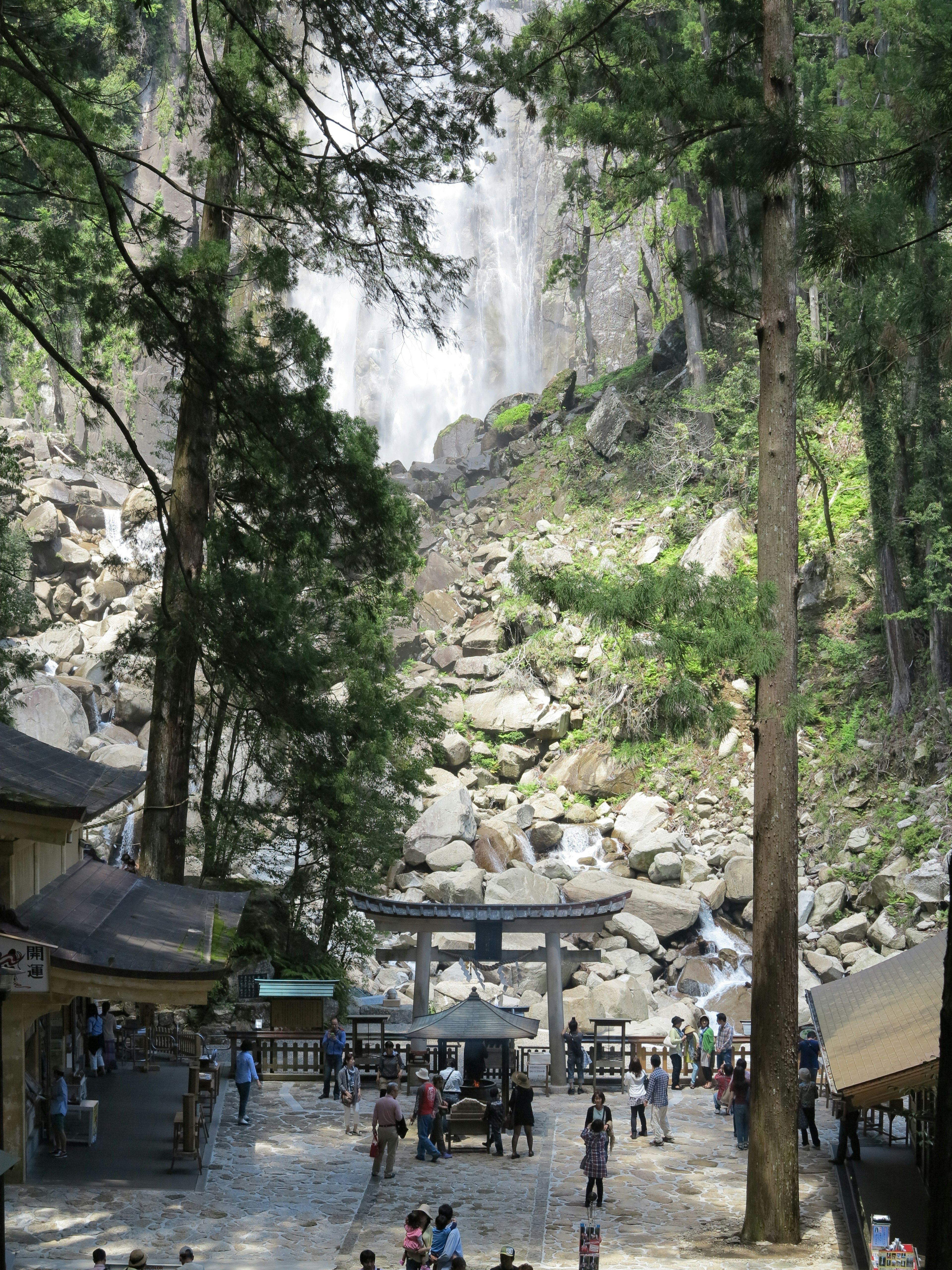 Pemandangan air terjun dekat kuil dengan pengunjung