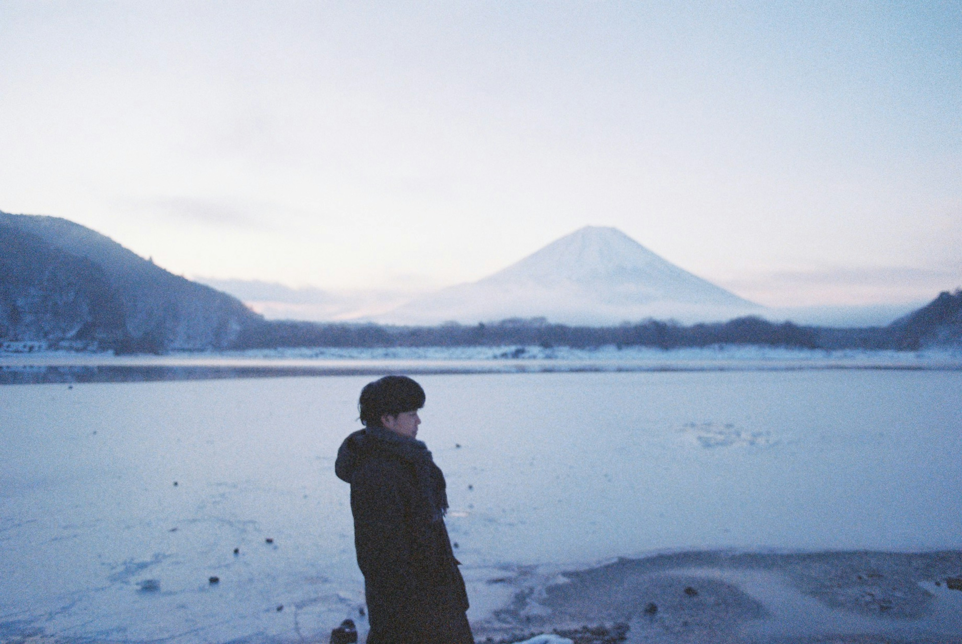 Silhouette d'une personne se tenant avec le mont Fuji enneigé en arrière-plan