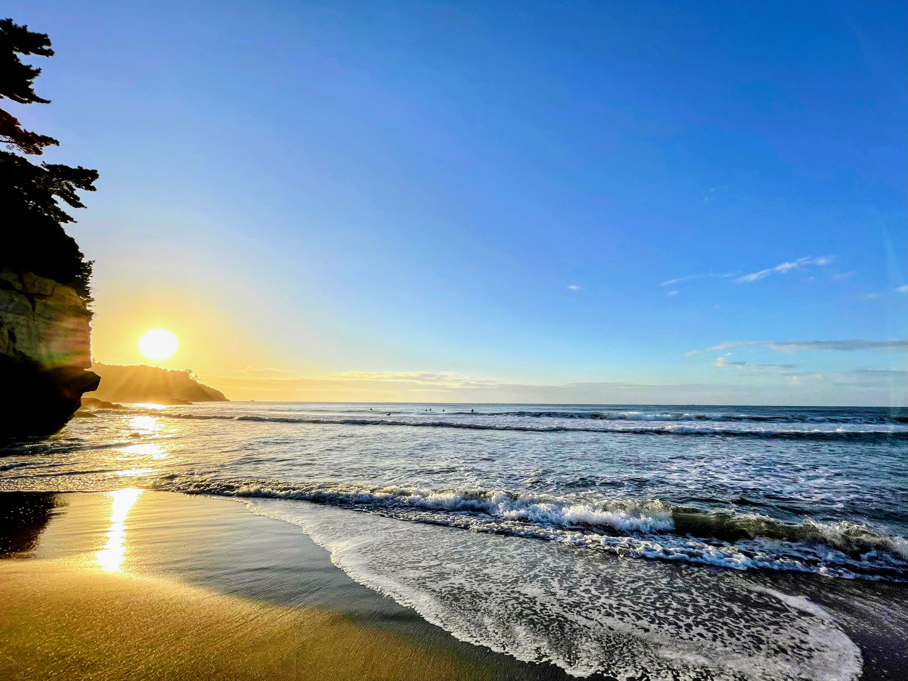 Magnifique coucher de soleil sur l'océan avec des vagues et un ciel bleu clair