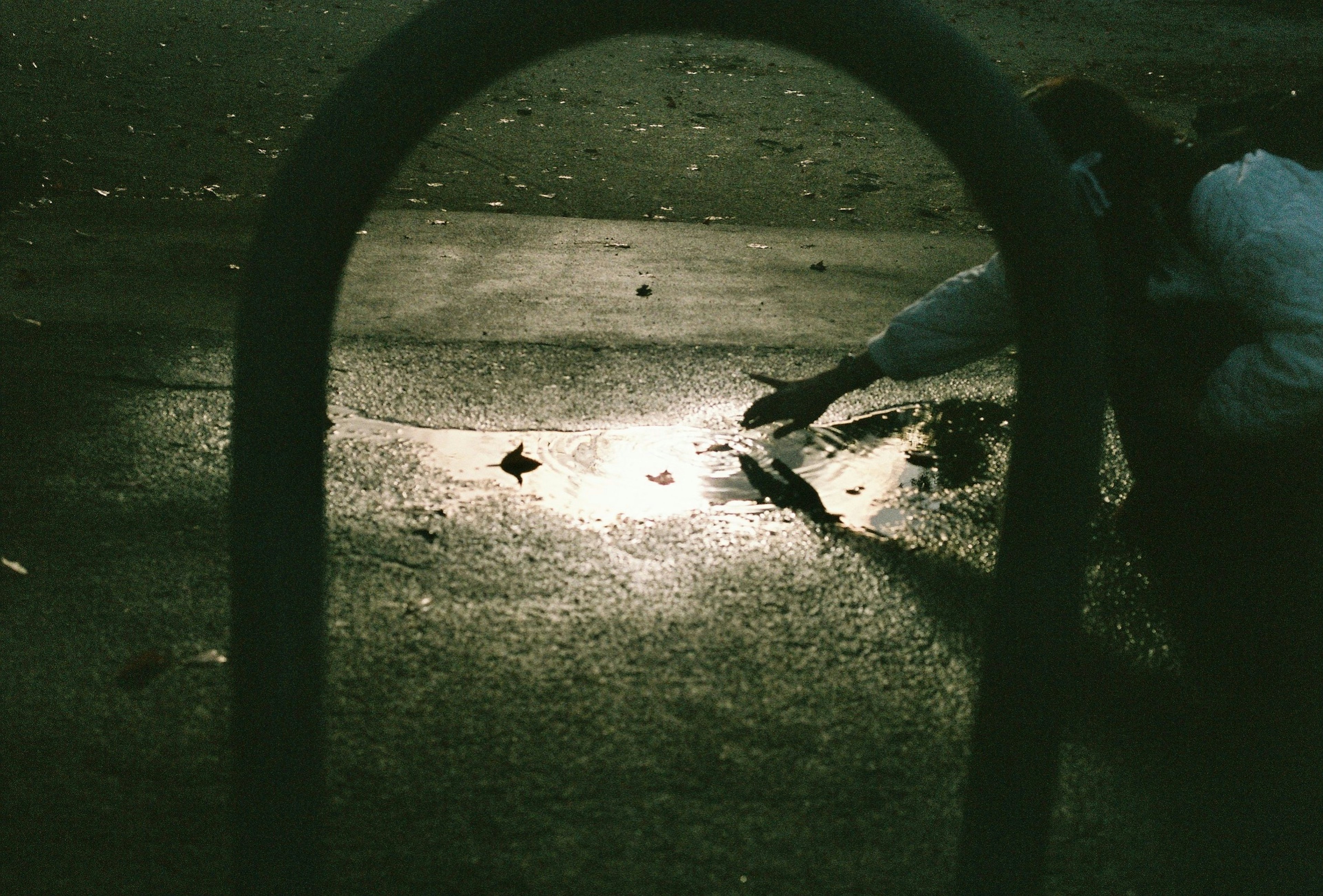 Niño tocando un reflejo en el suelo en un parque