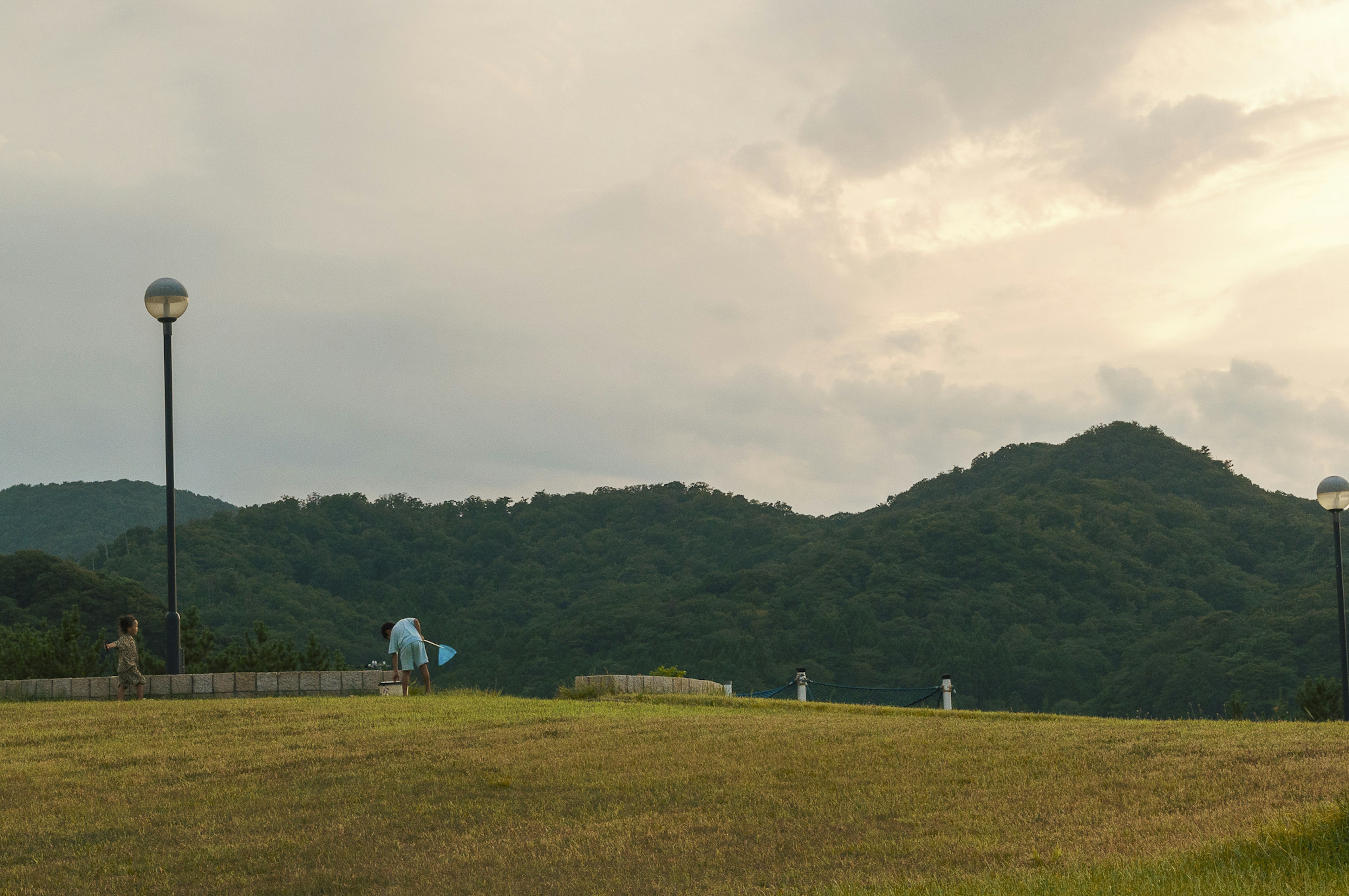 山と草原に囲まれた公園の風景と街灯