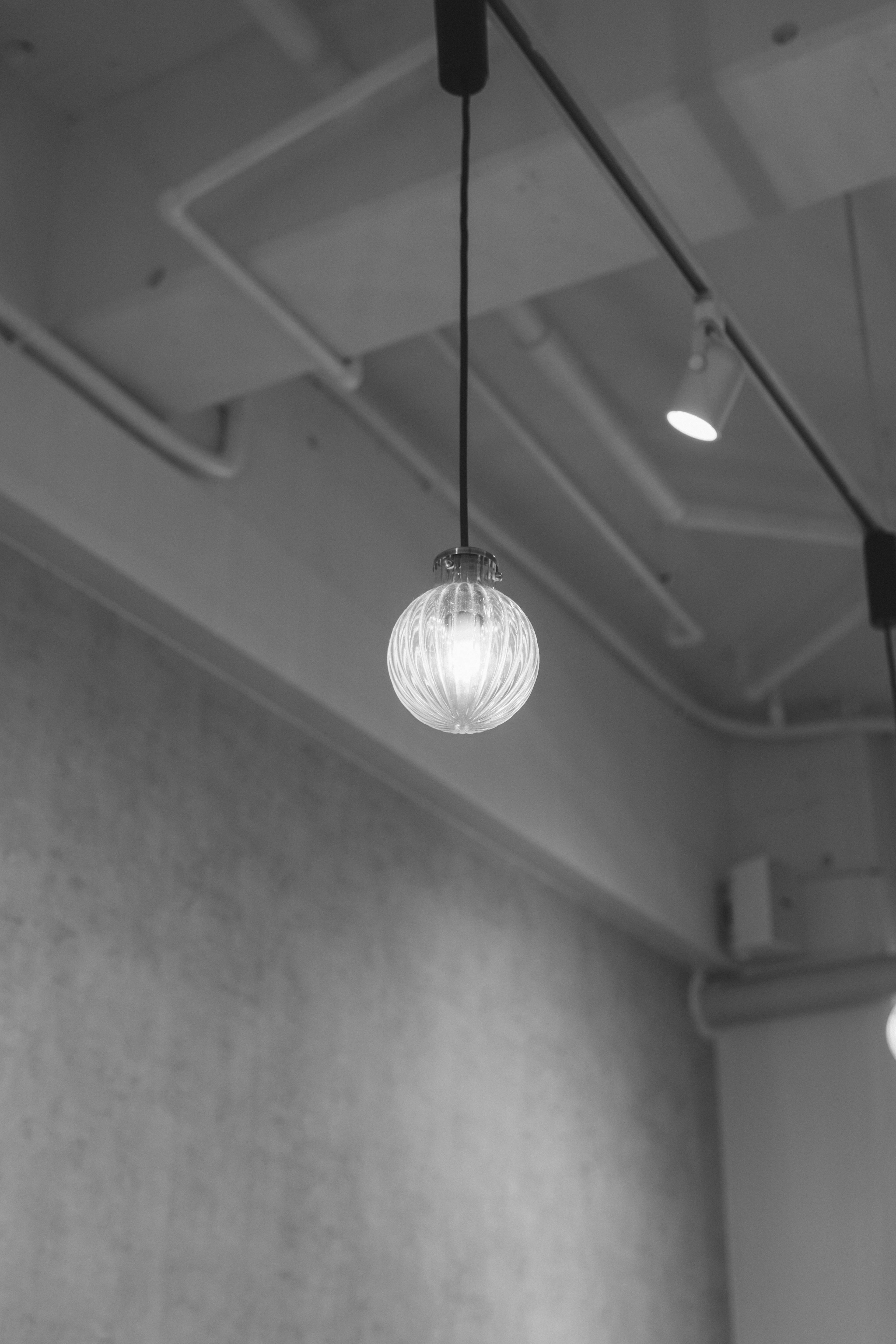 Immagine in bianco e nero di una lampada a sospensione dal soffitto