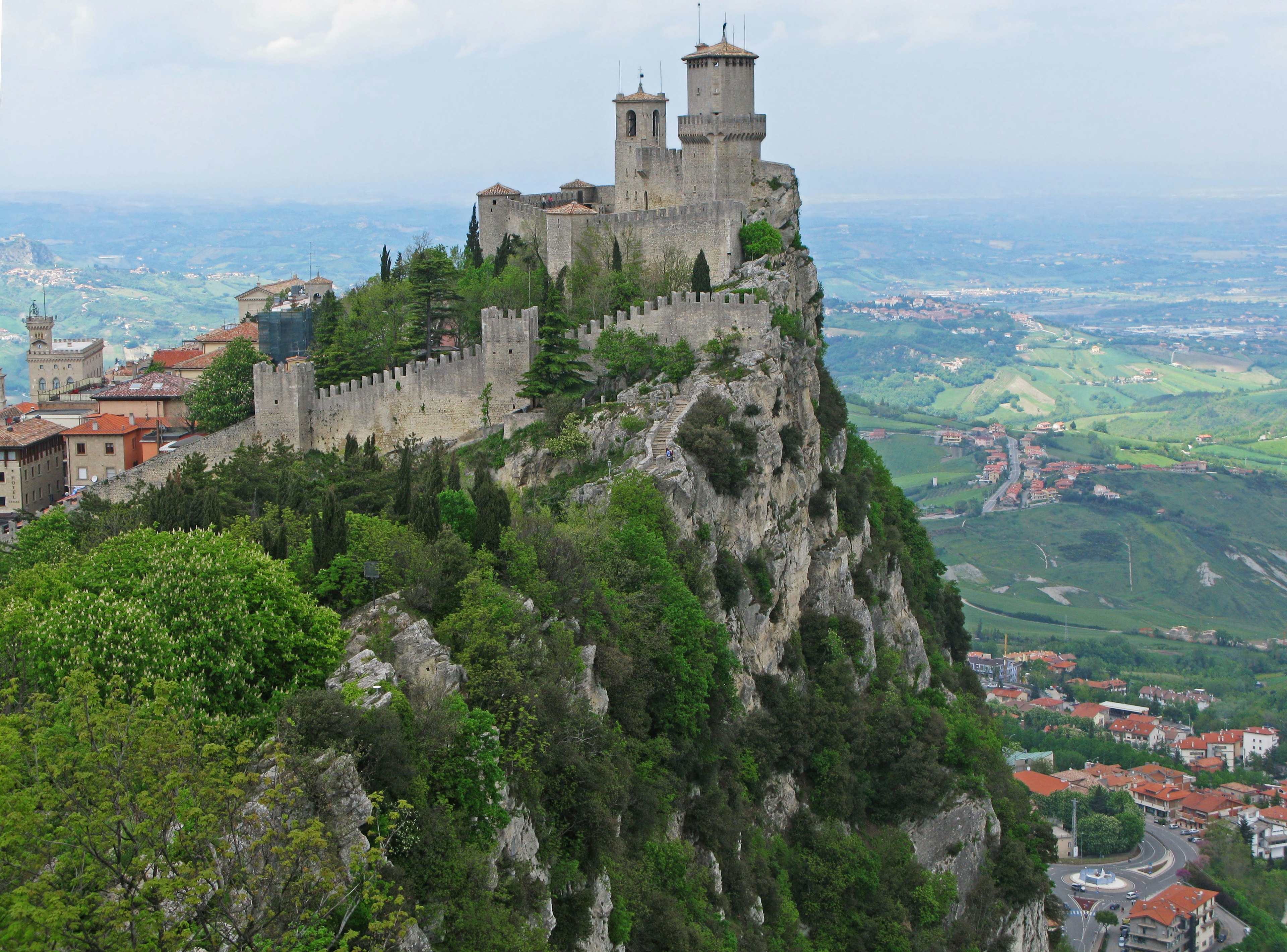 Antigua fortaleza en una montaña en San Marino con vegetación exuberante