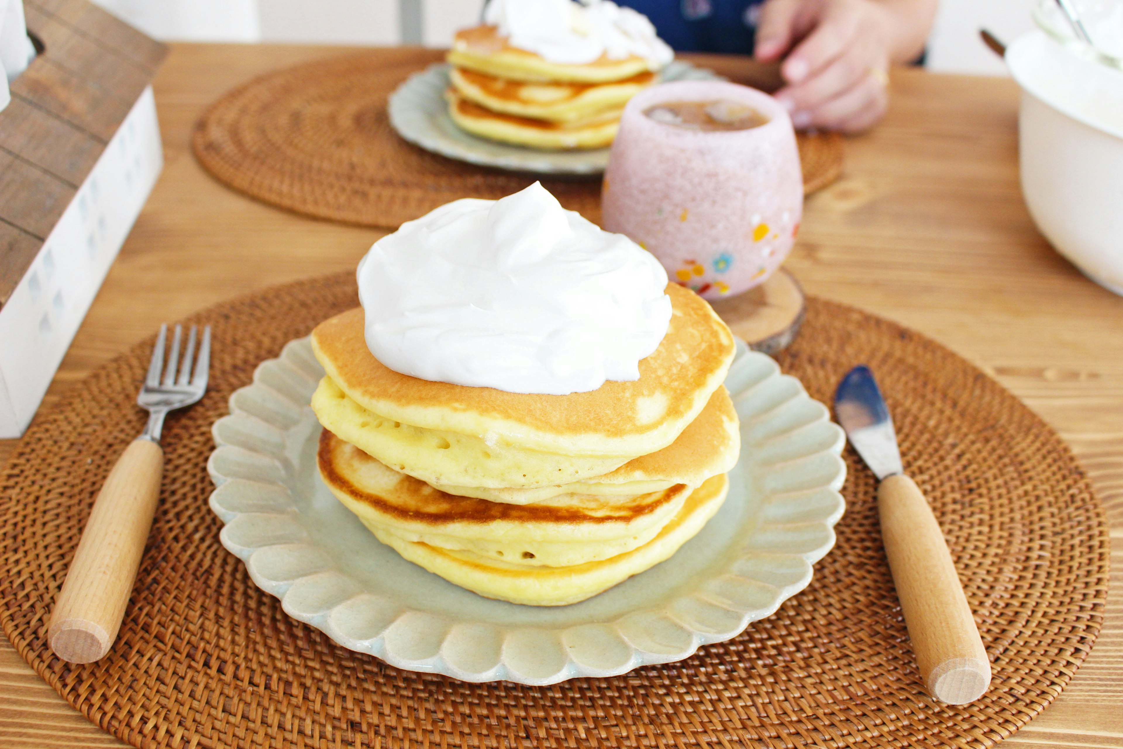 Pancake soffici guarniti con panna su un tavolo da pranzo