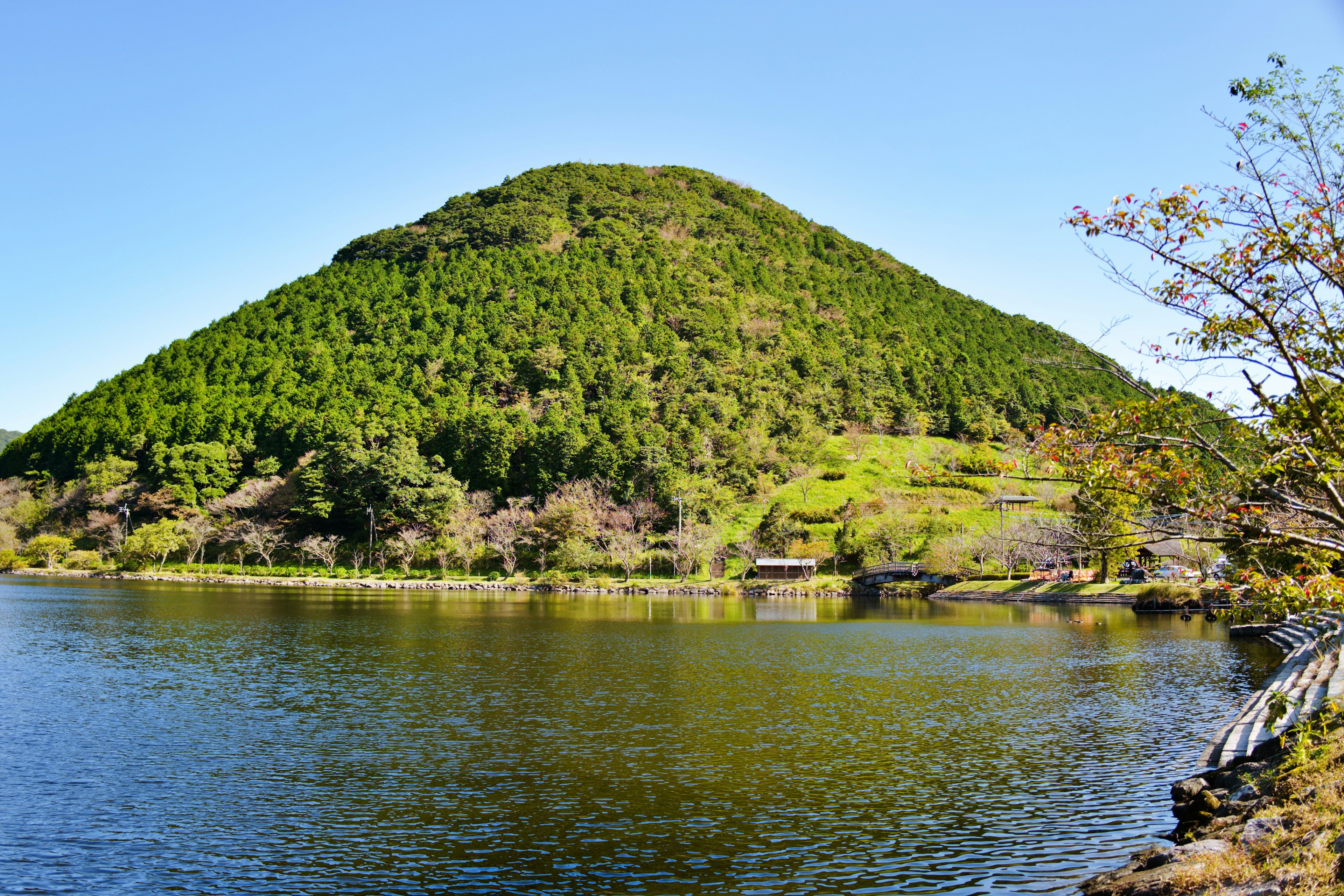 Bukit hijau subur yang menghadap danau tenang