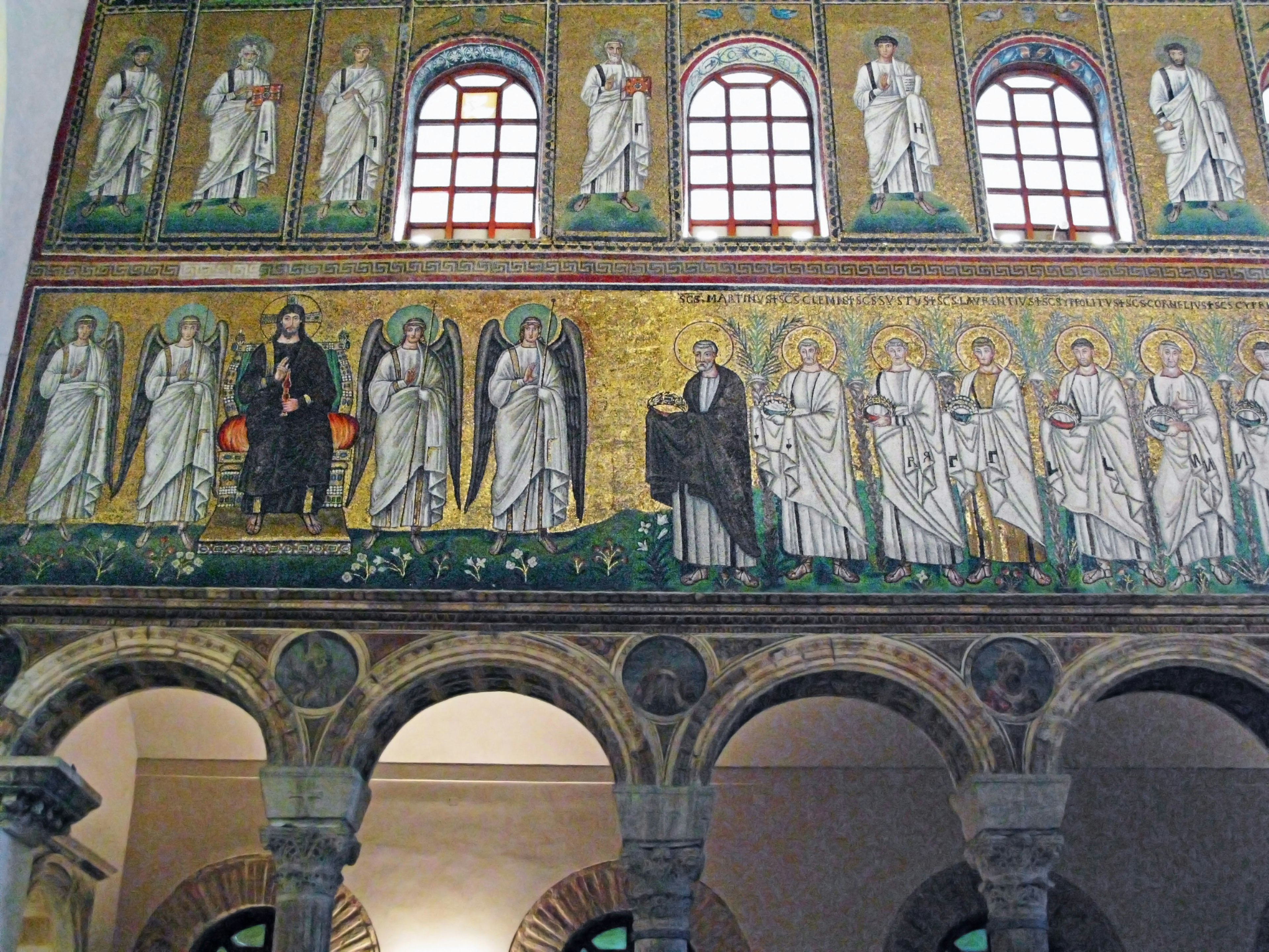 Interior de una iglesia con murales de mosaico dorados que representan santos