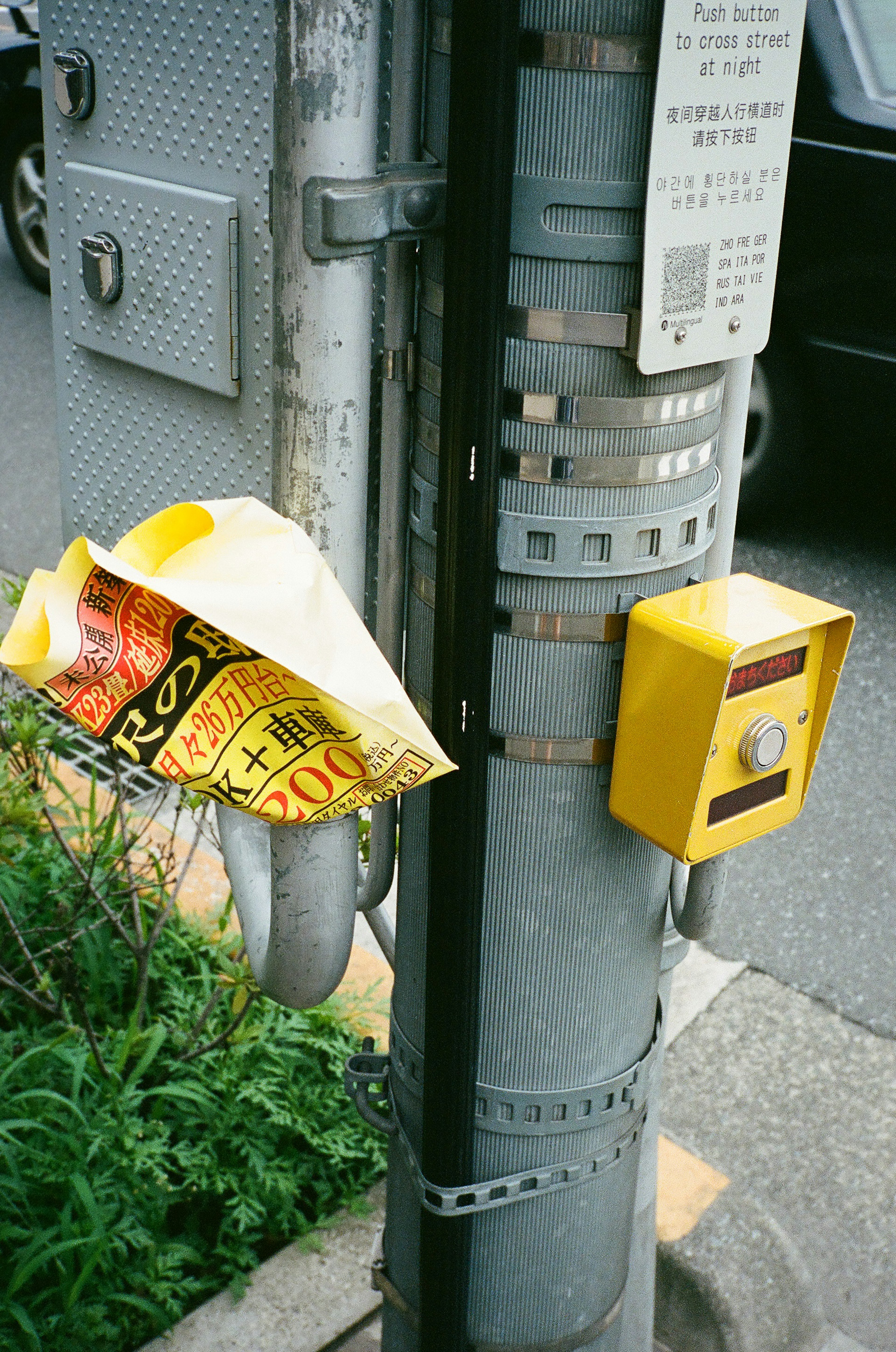 Gelbe Werbung, die an einem Verkehrspfosten mit einem Knopf hängt