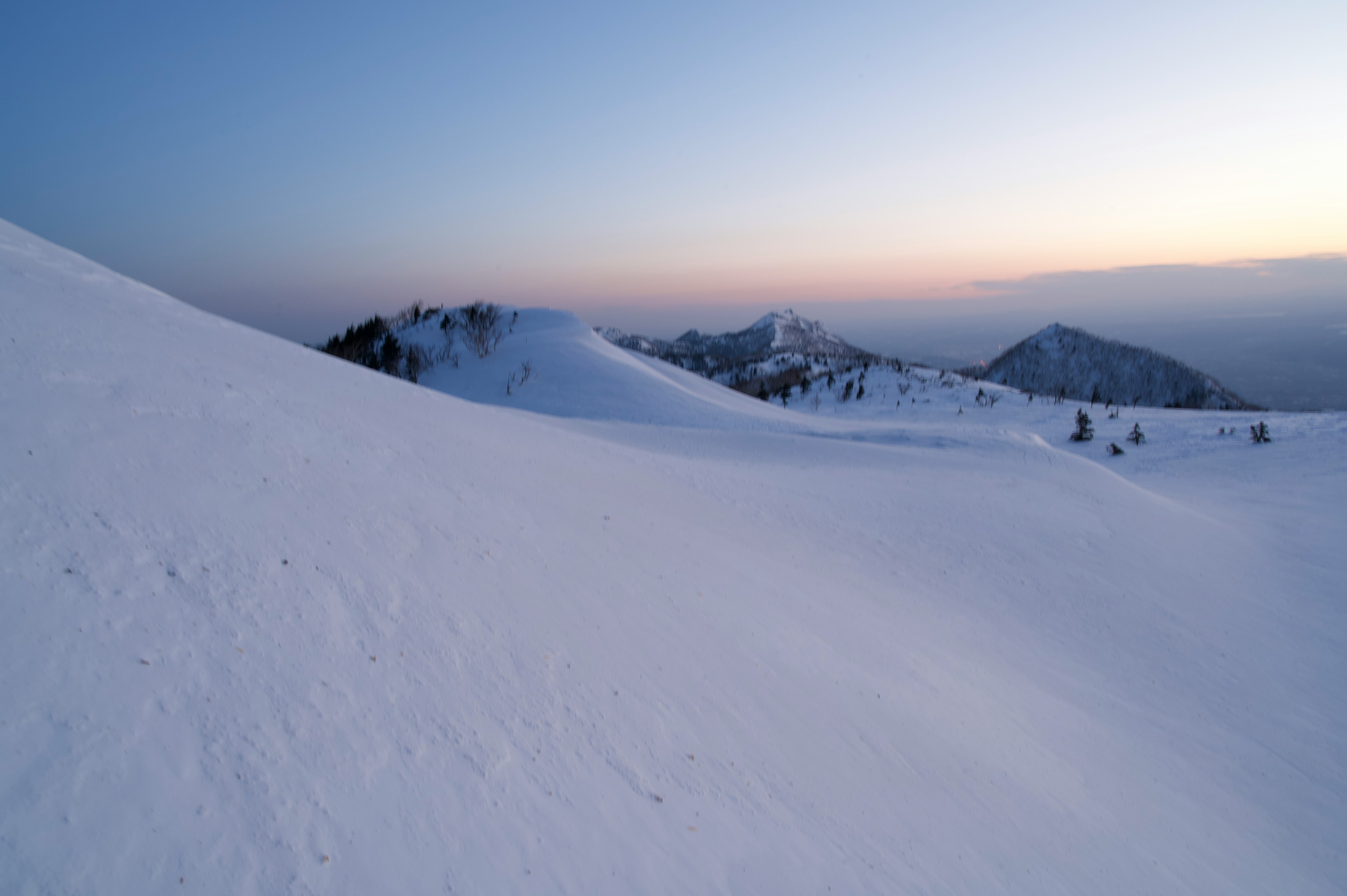 雪に覆われた山の風景 日没時の柔らかな光