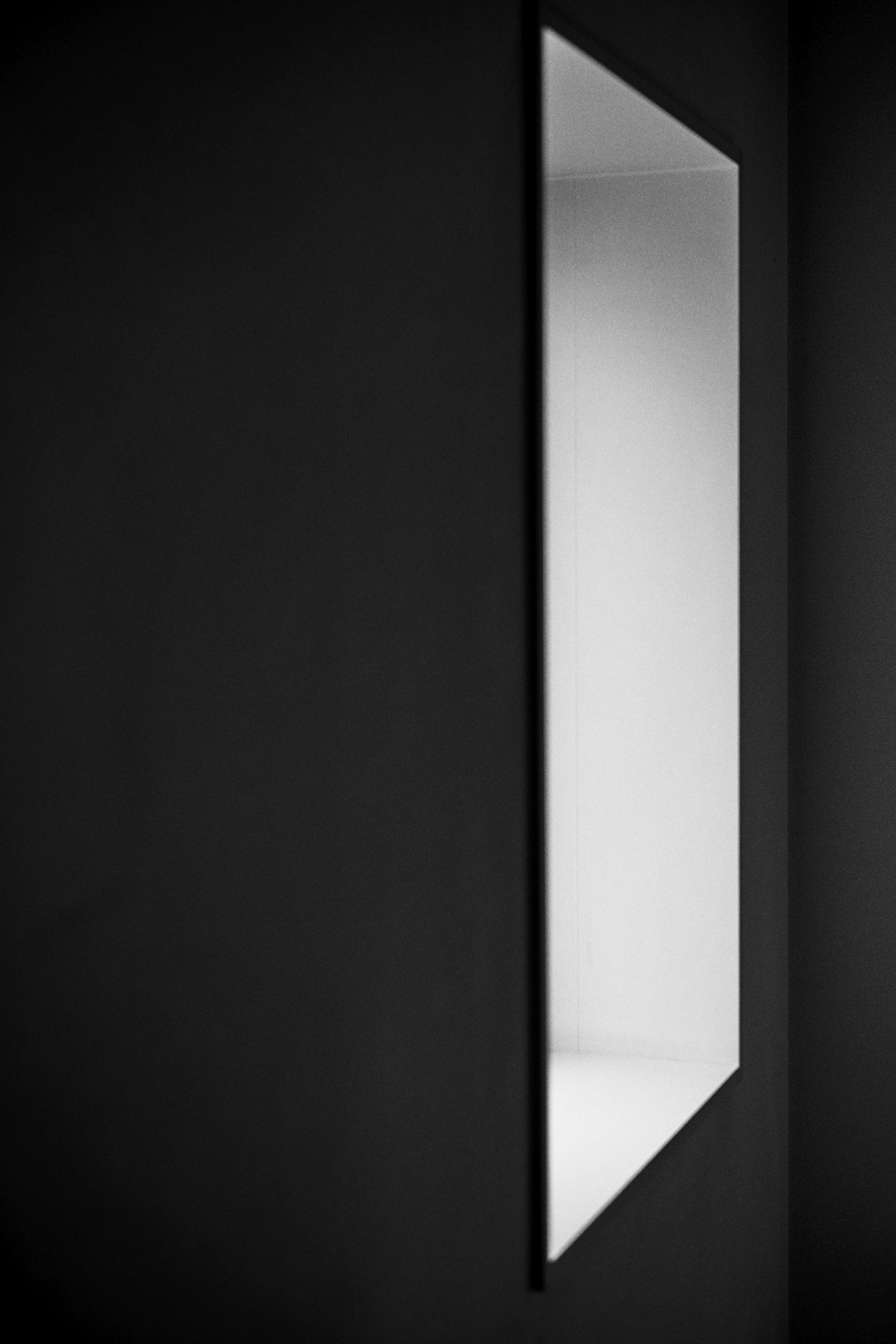 Image of a slender mirror mounted on a black wall