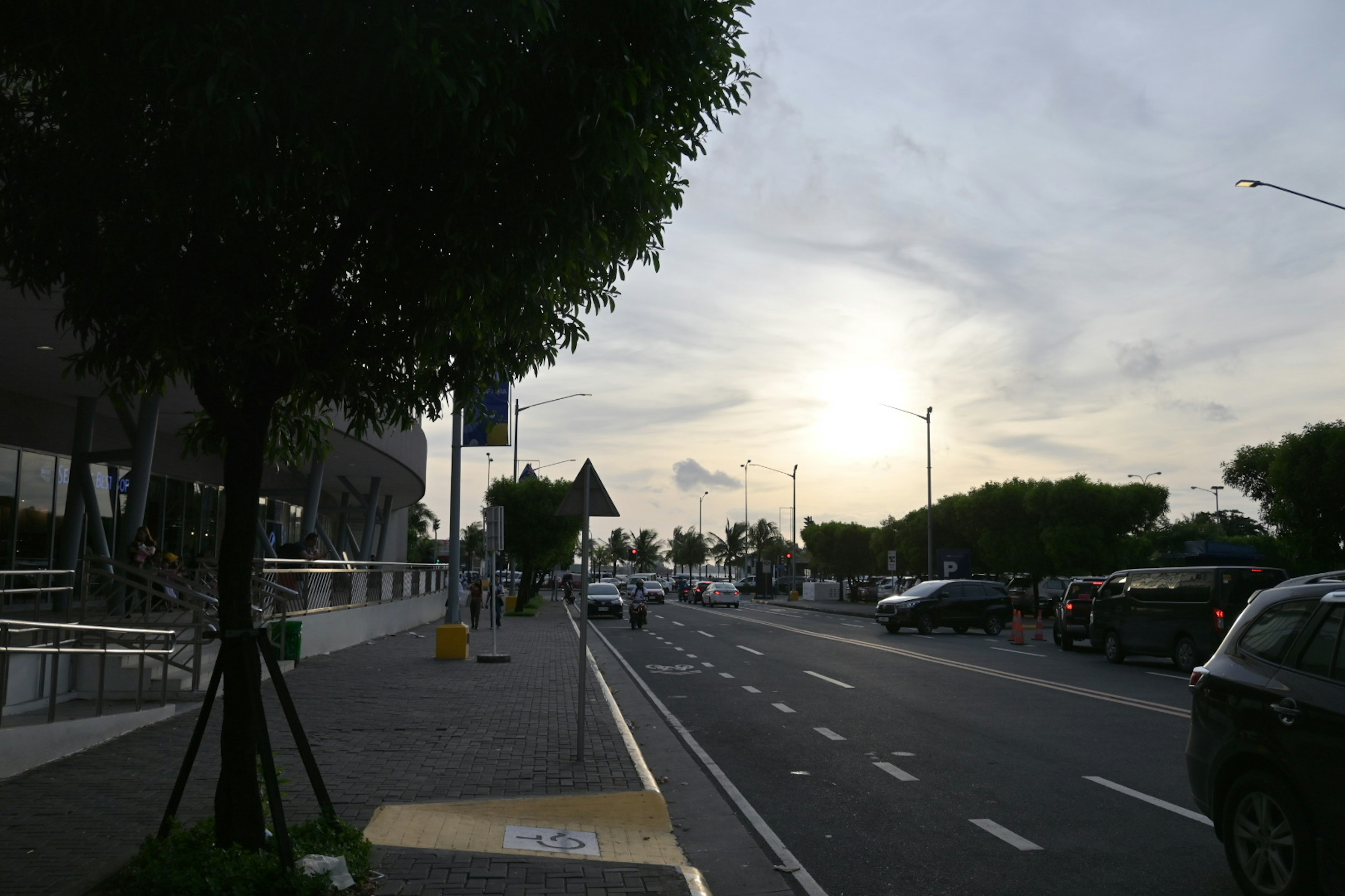 夕暮れ時の街並みと車両が並ぶ道路