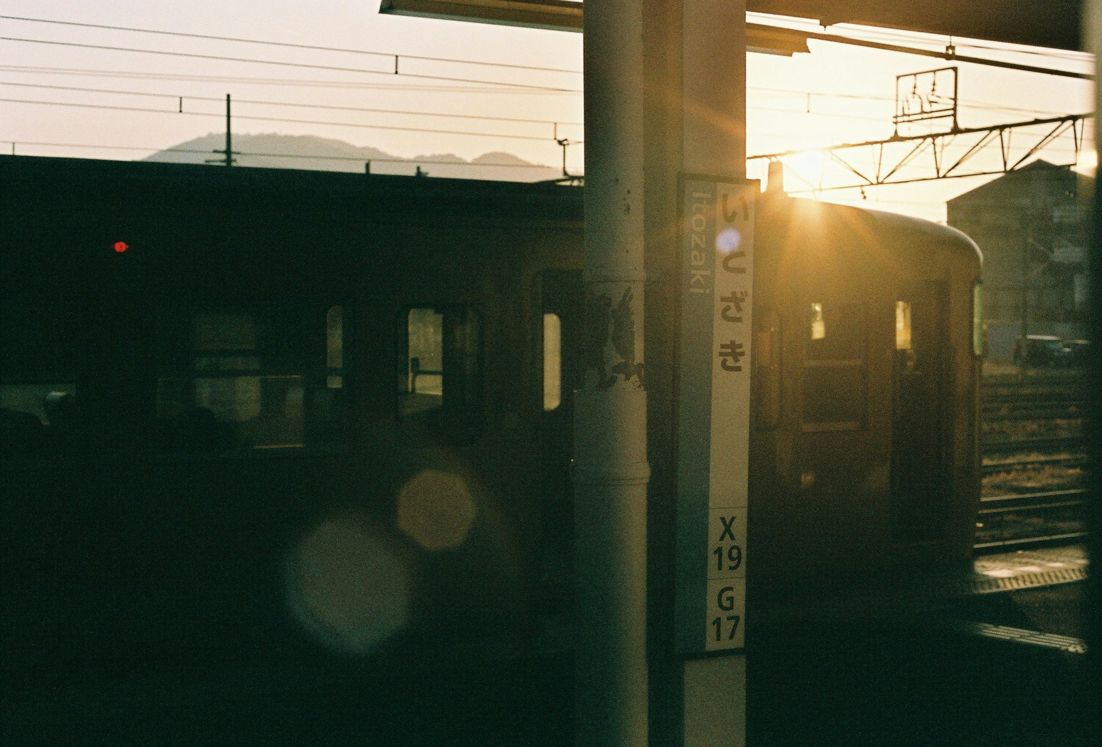 夕日が照らす駅での列車のシルエット