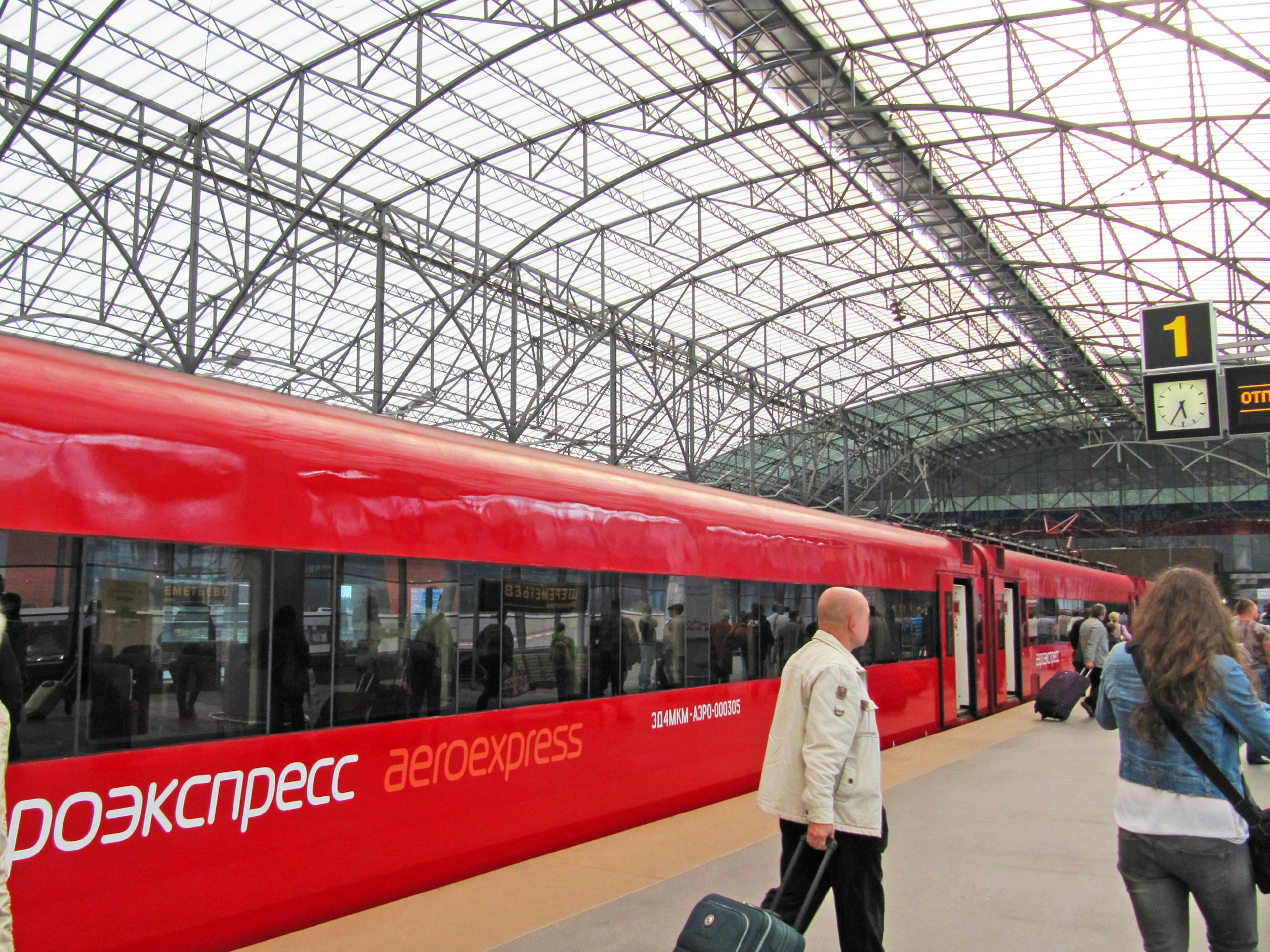 Red express train at a station with a glass roof