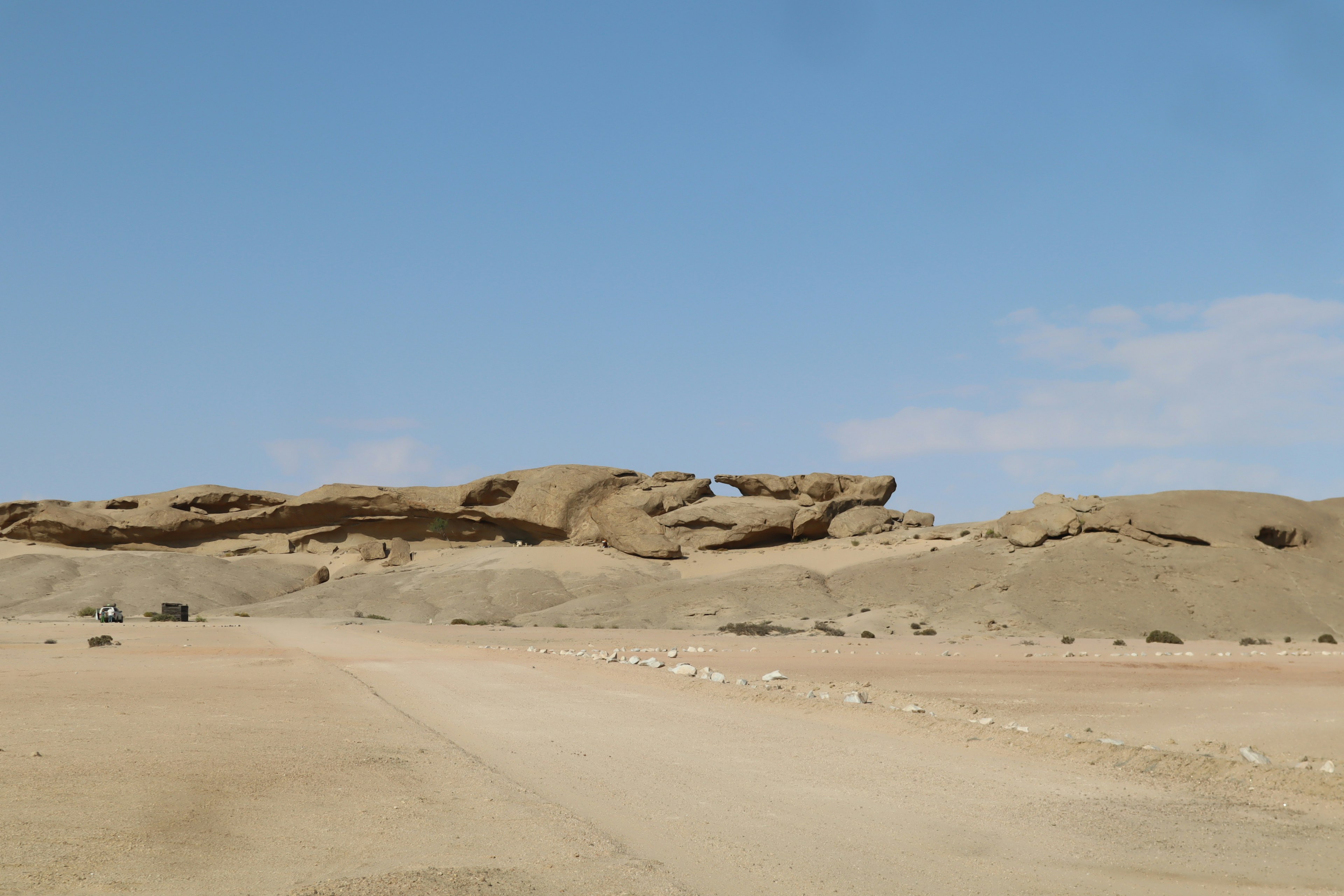 Desert landscape featuring rocky formations and a clear blue sky