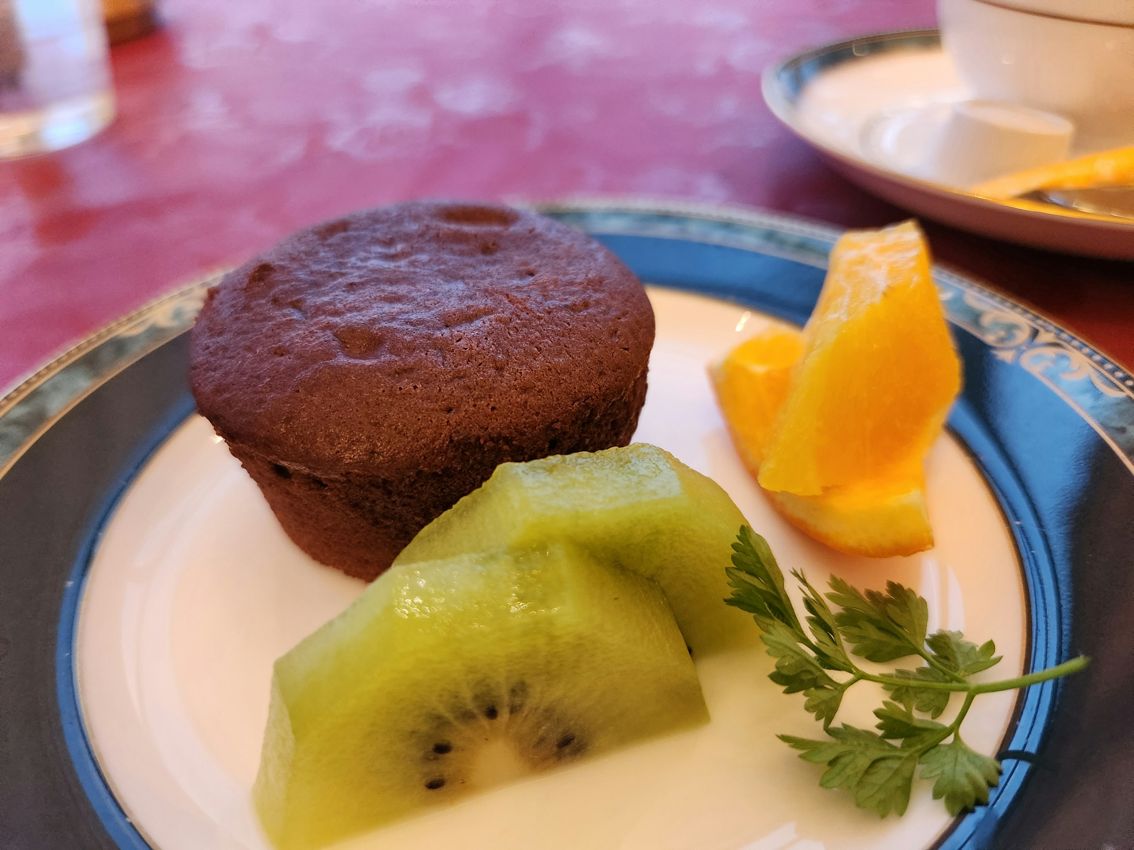 Chocolate muffin served with slices of kiwi and orange