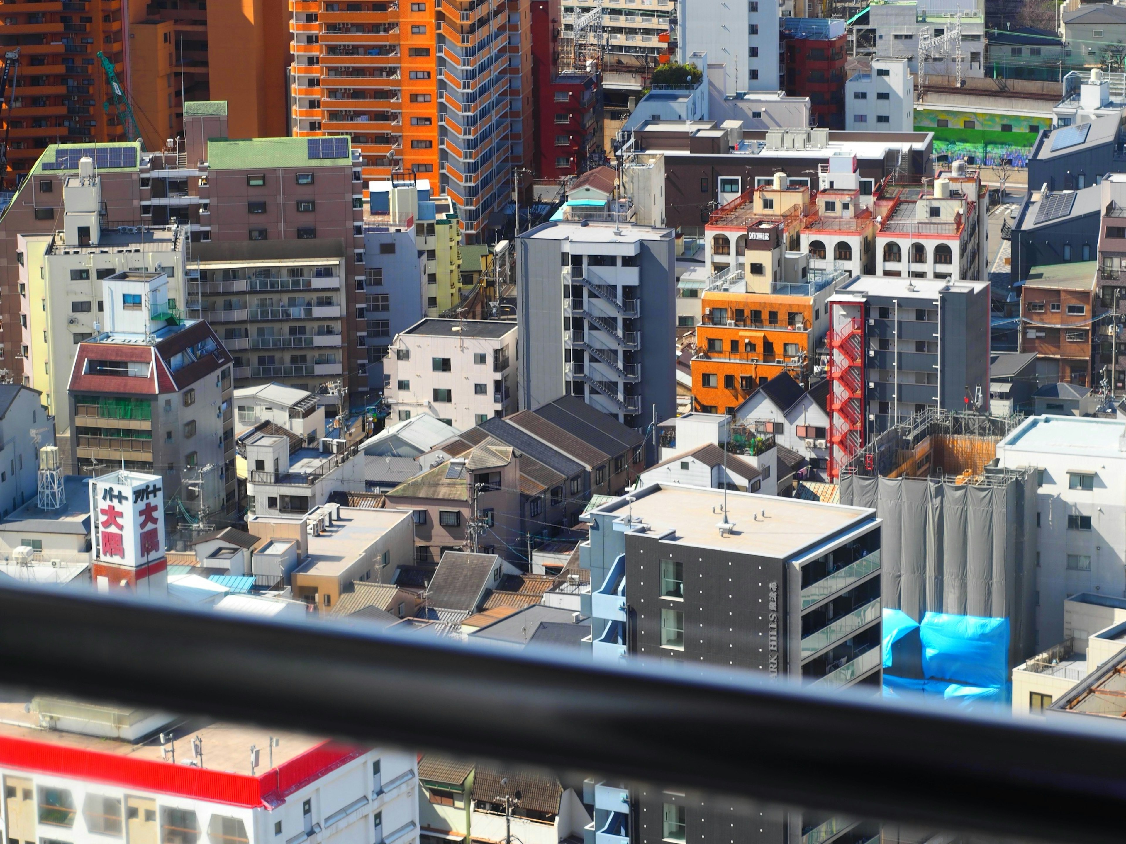 都市の高層ビルとカラフルな建物が見える風景