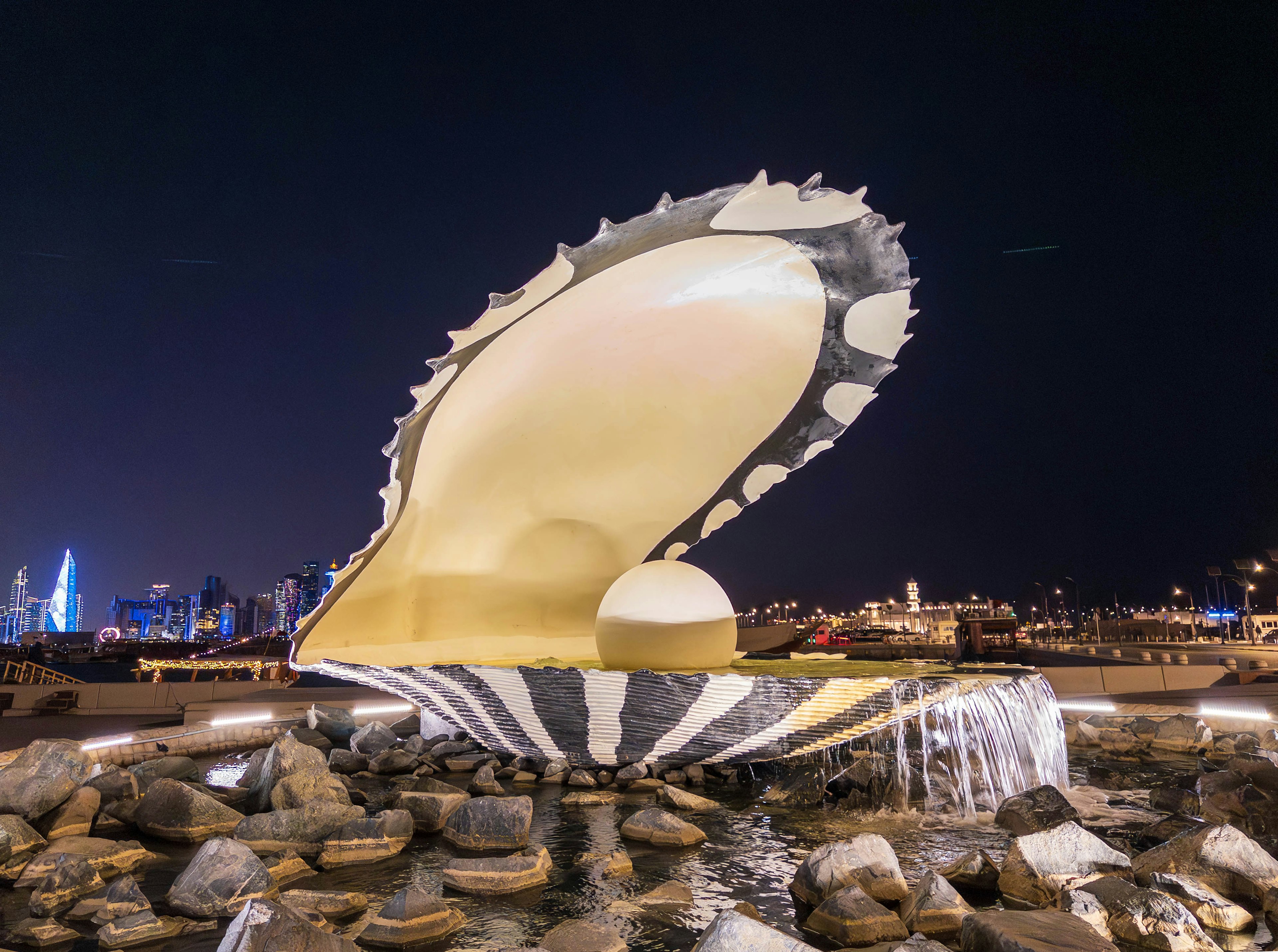 夜の海の貝殻の噴水 彫刻のようなデザインと明るい照明