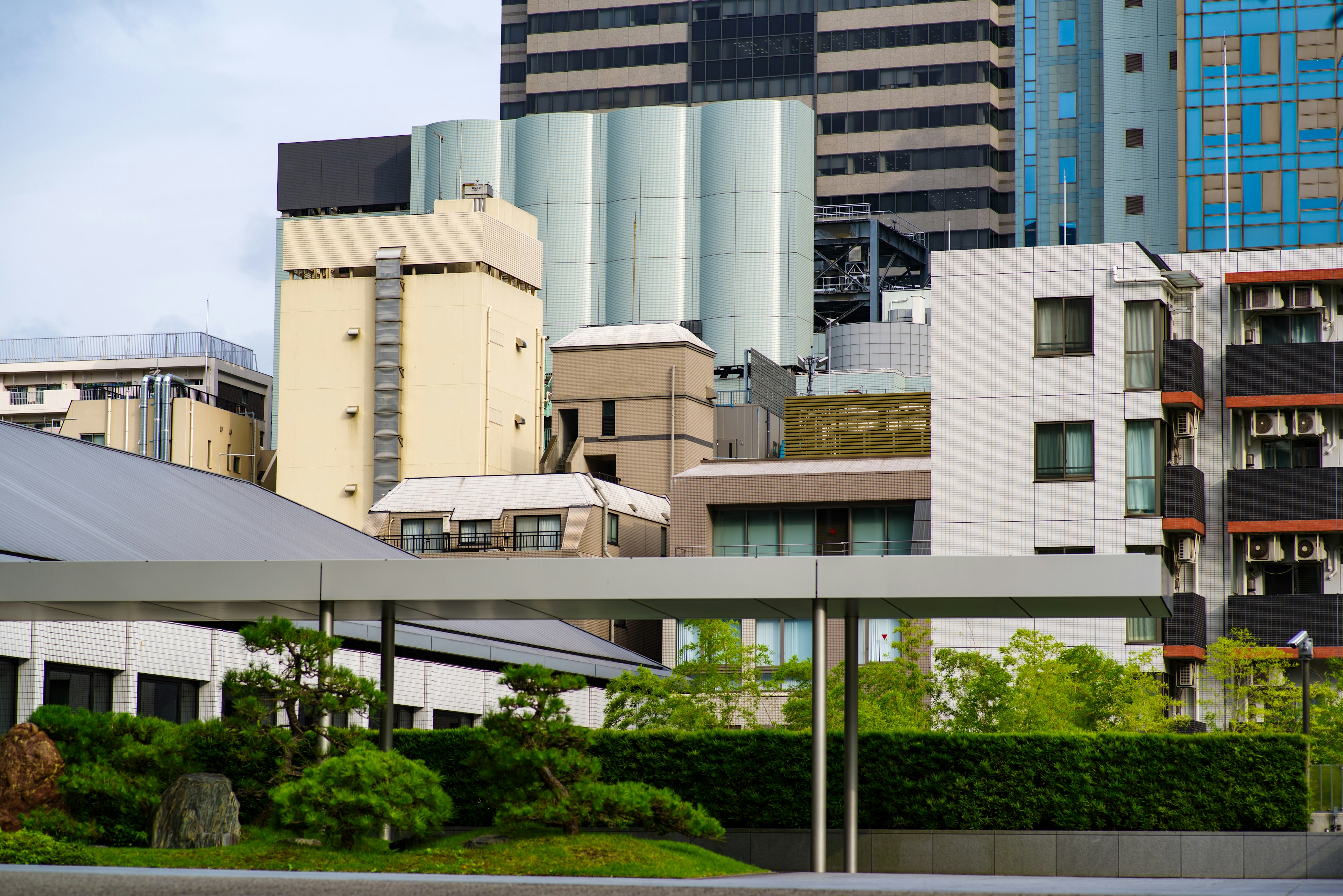 Urban landscape featuring skyscrapers and residential buildings with a distinctive green garden