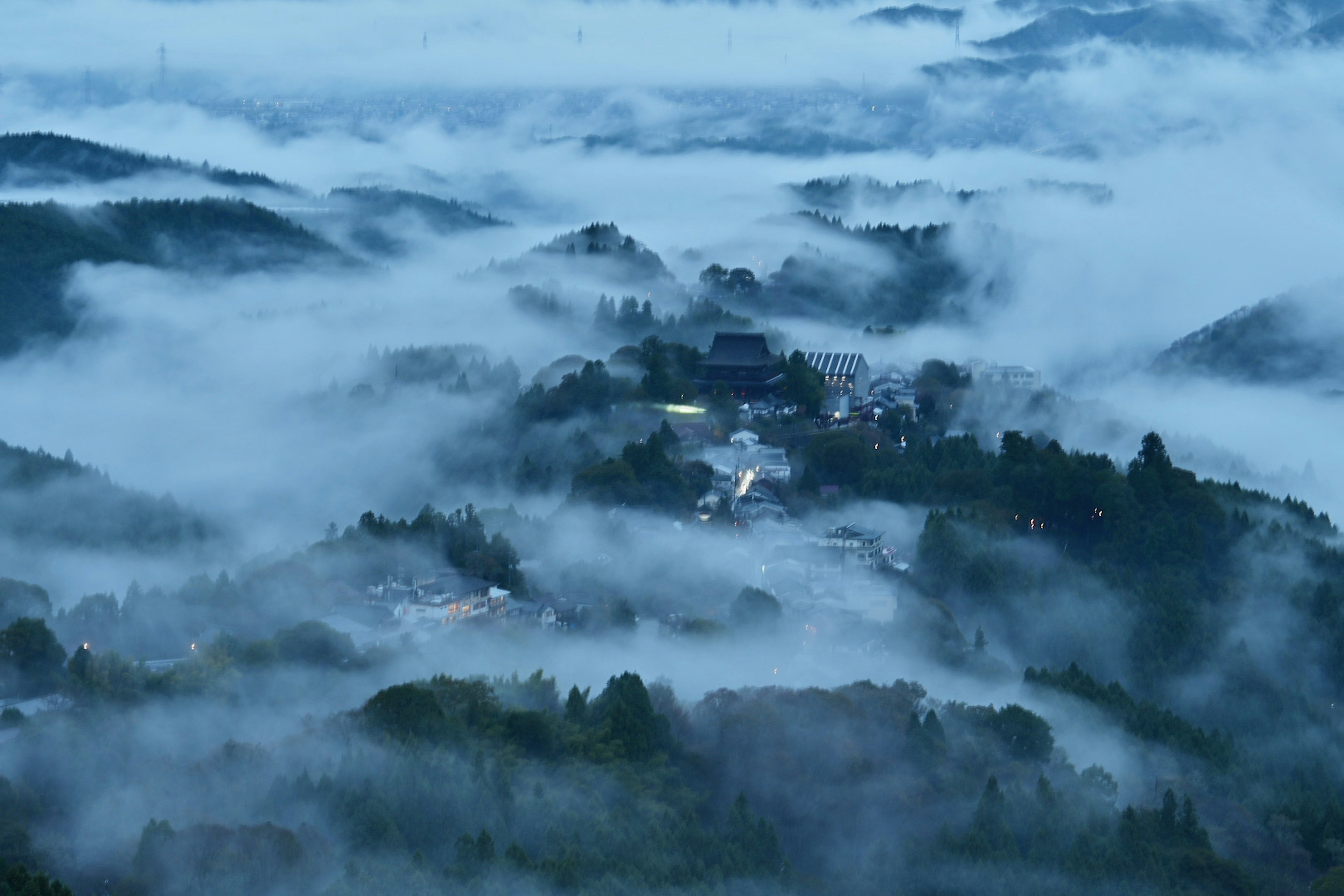 Ein in den Bergen verstecktes Dorf, umhüllt von Nebel