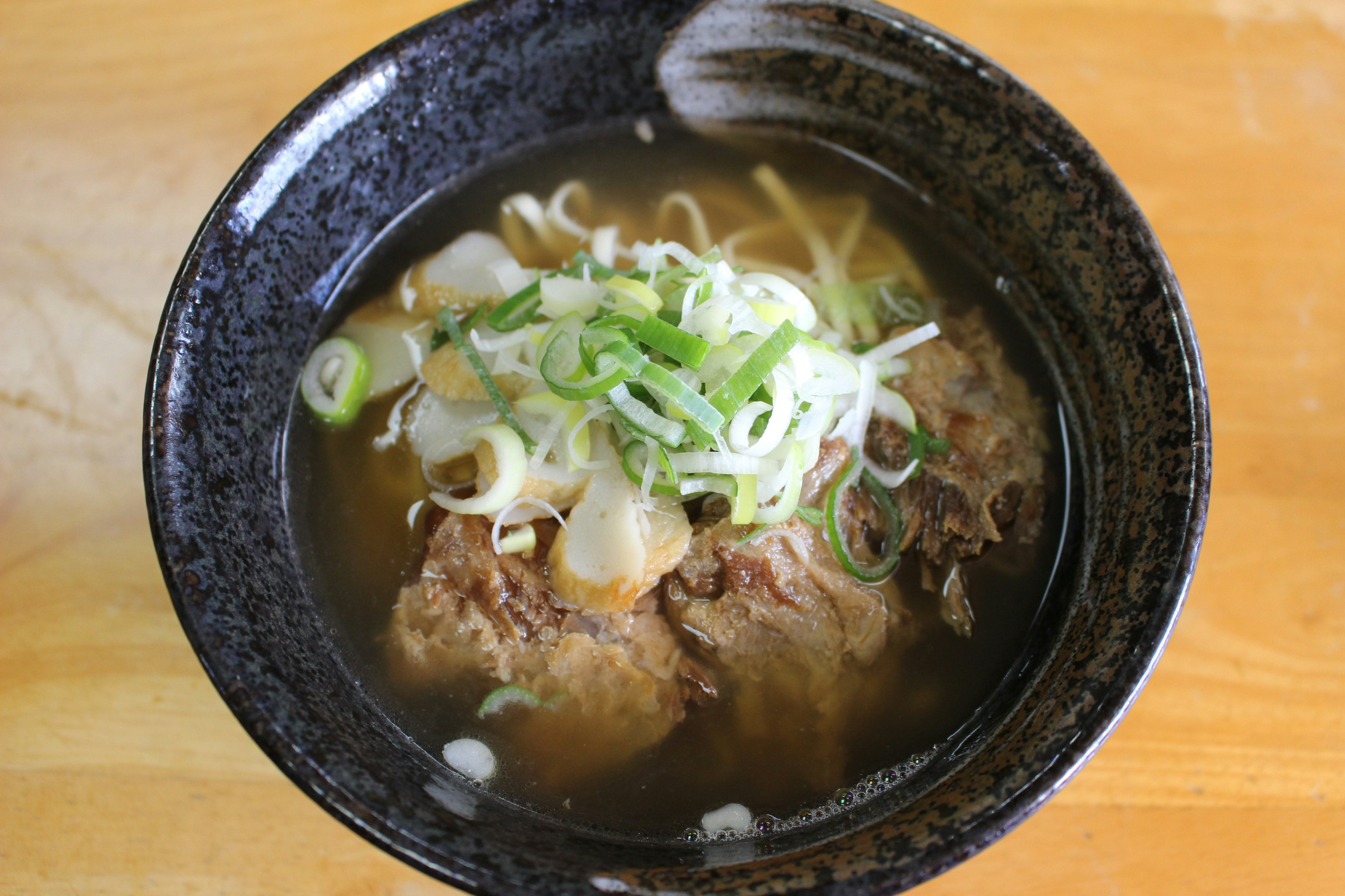 Mangkuk sup daging dengan bawang hijau