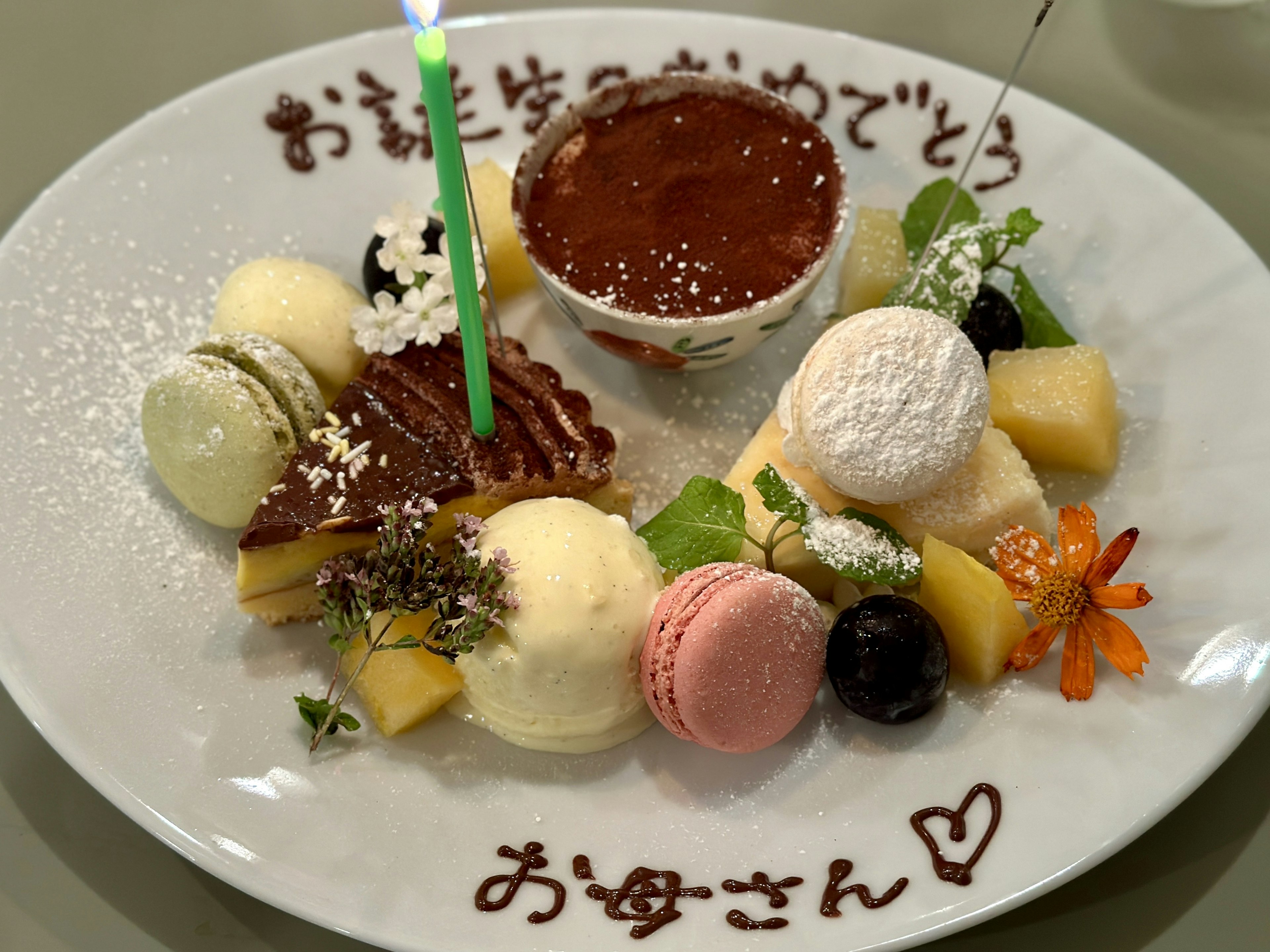 Plato de postre colorido con un mensaje de cumpleaños y una vela